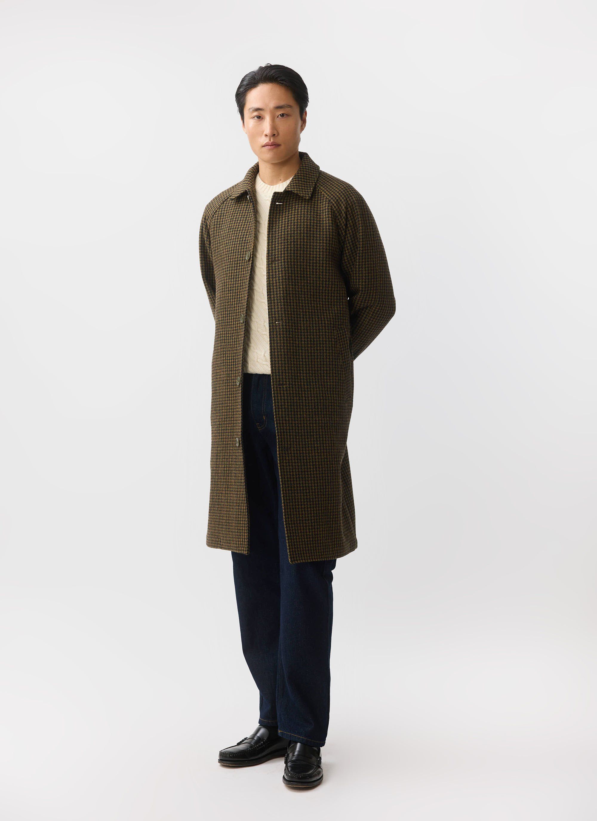 A model wears the Percival Dickens Car Coat in Watcher Check over a cream knit jumper and dark jeans.