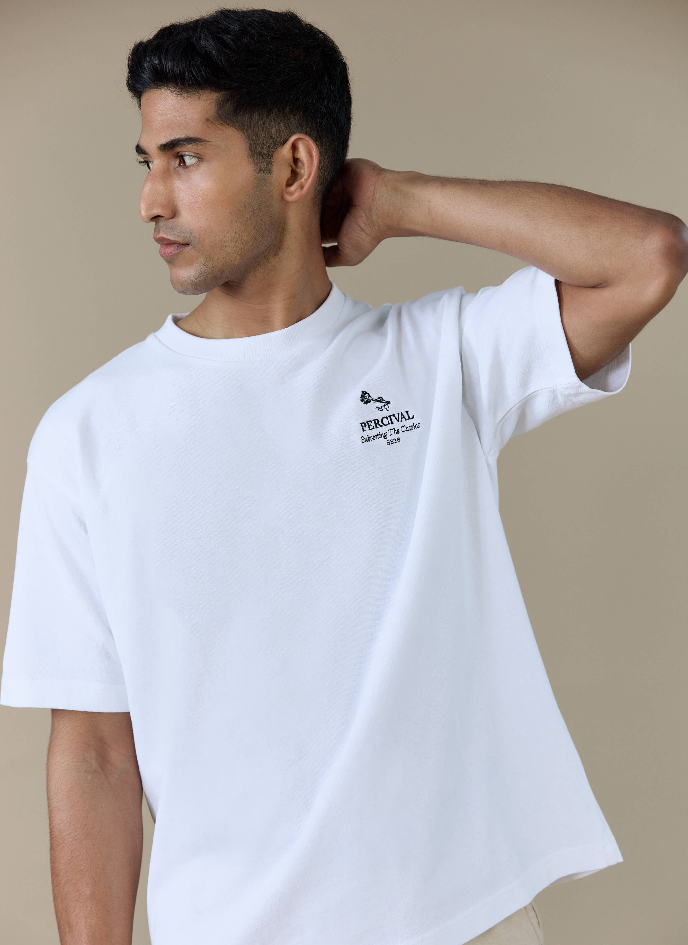 Model wearing the Percival Perci Waters Oversized T-shirt in white organic cotton, featuring the front chest embroidery.