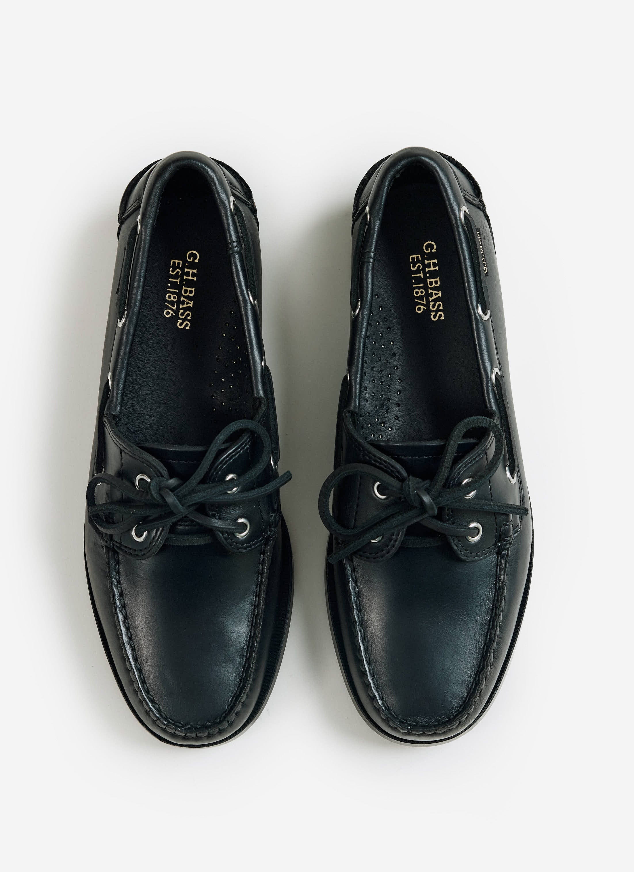 A flat lay of the black G.H. Bass Jetty II Boater 2 Eye leather shoes from Percival, showing the gold foil branding.