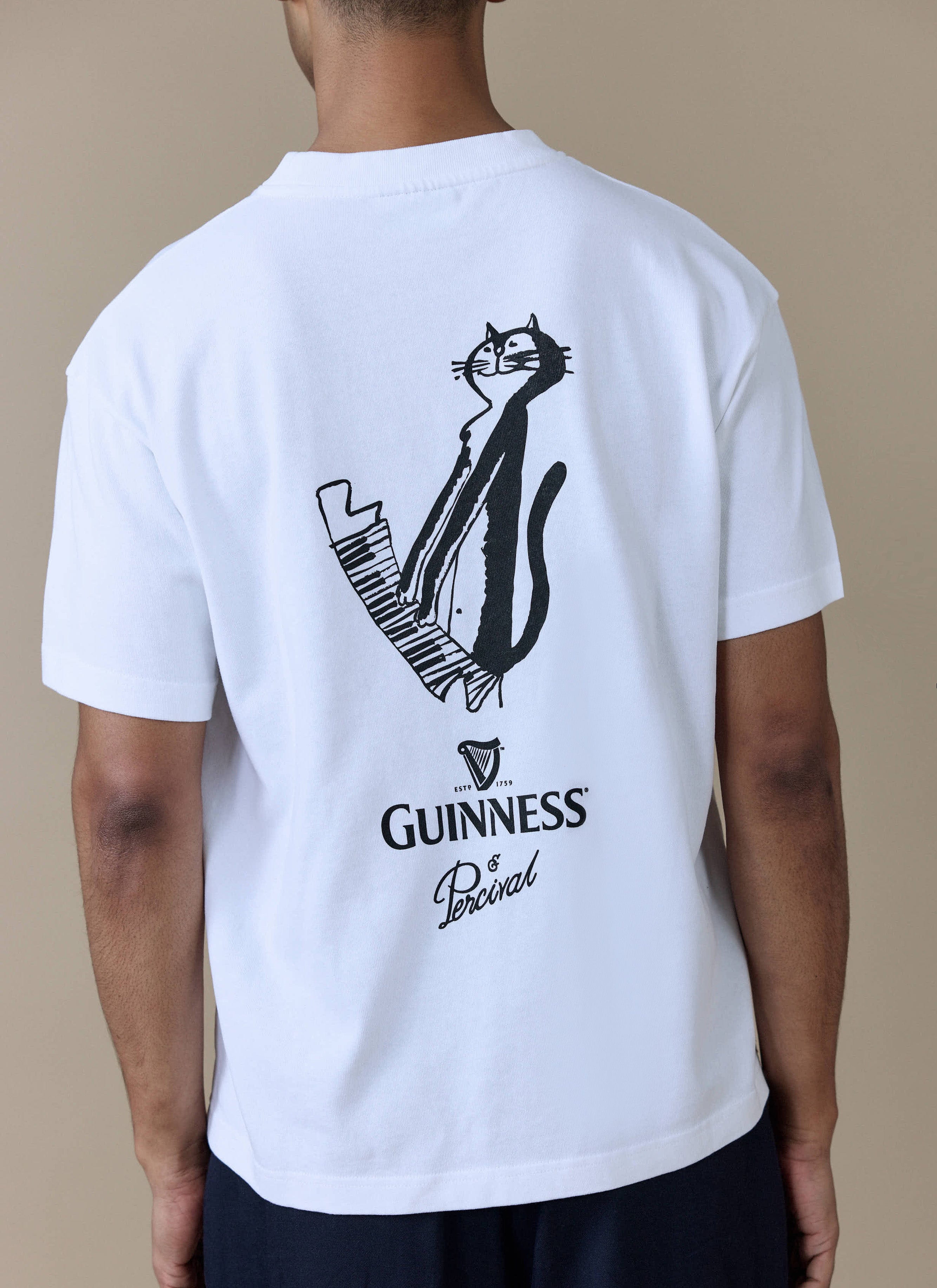 Back view of the white Percival x Guinness oversized t-shirt showing the hand-illustrated cat playing the piano graphic.