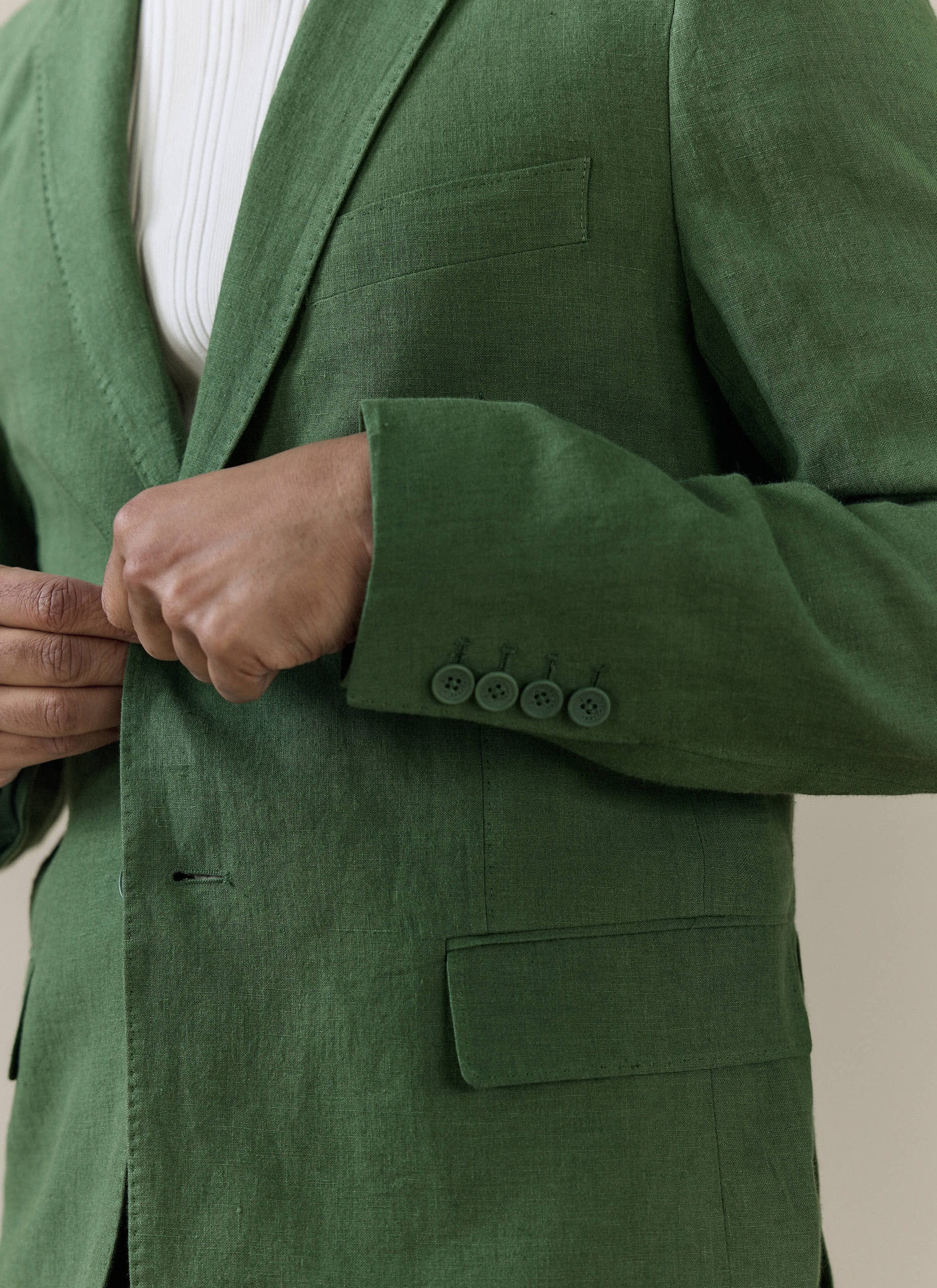 Close-up of the Percival Slim Fit Classic Blazer in forest green linen, showing the textured fabric and four-button cuff.