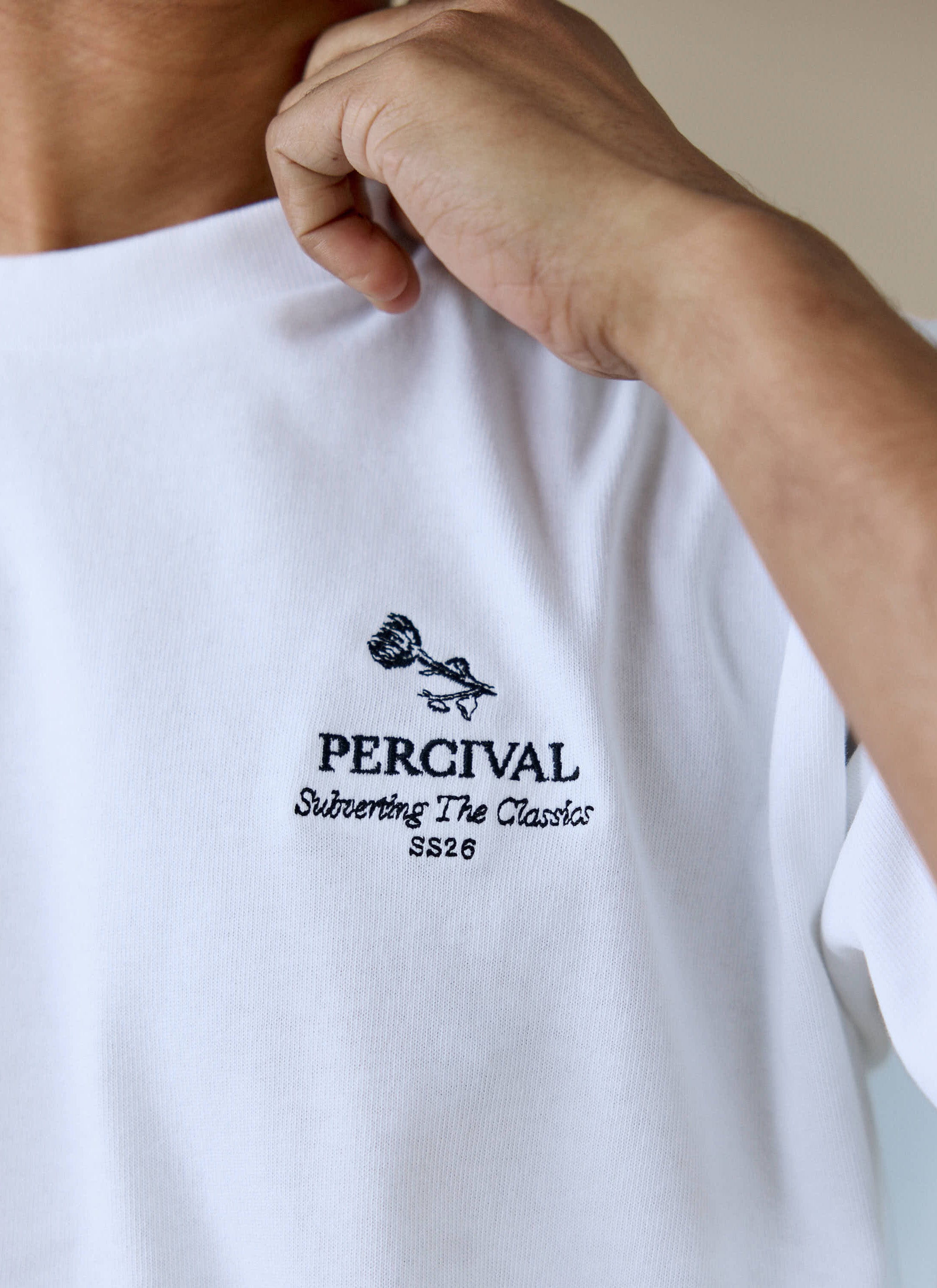 Close-up of the black chest embroidery on the Percival Perci Waters Oversized T-shirt in white organic cotton.