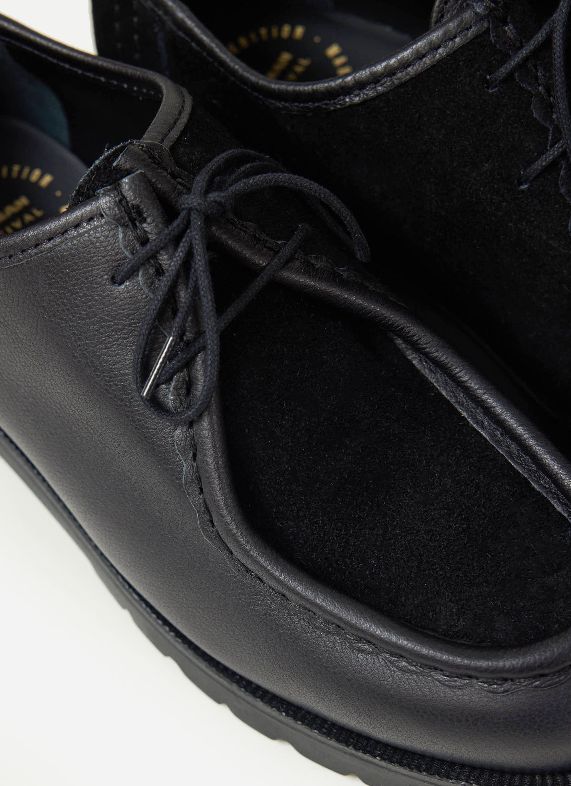 A close-up of the Percival x Kleman Padror shoe in black, highlighting the patchwork leather and suede upper.