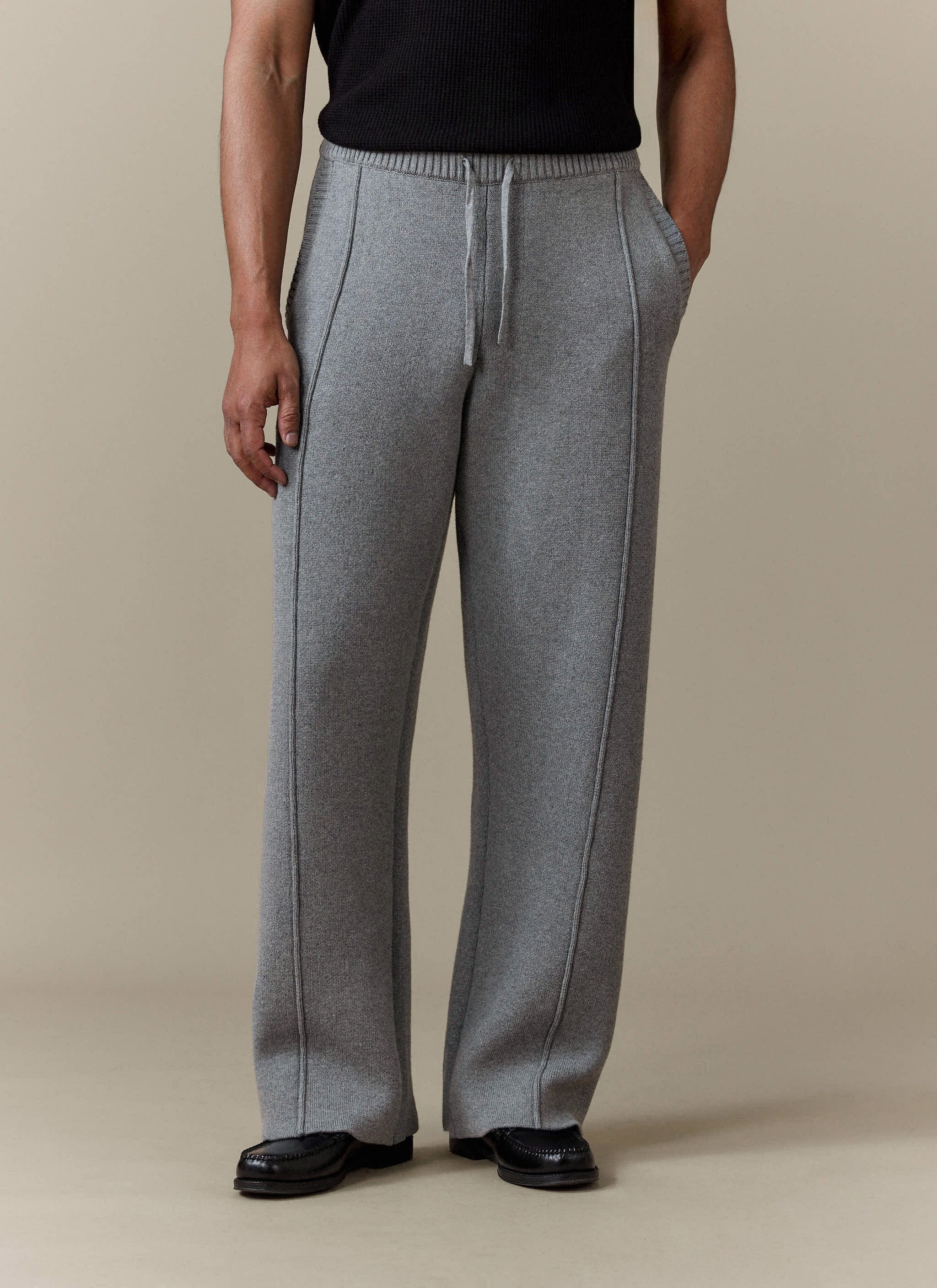 A model wears the grey cotton Chronicle Knitted Straight Leg Trackpant by Percival, showing the straight fit and seam detail.