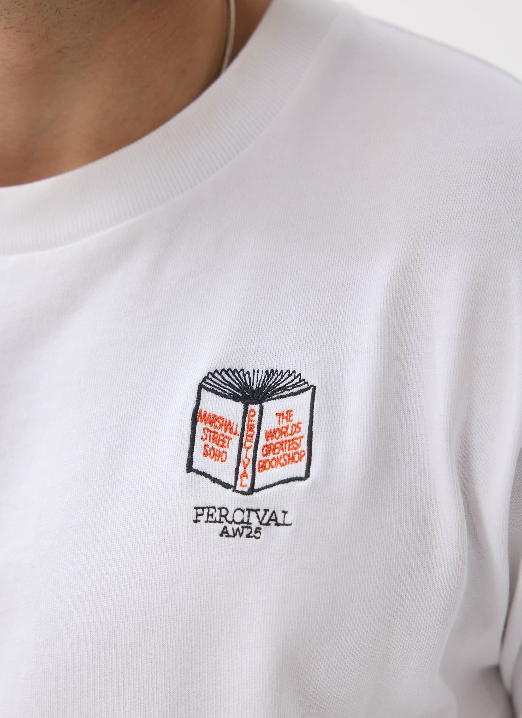 A close-up of the embroidered book graphic on the chest of the white Greatest Bookshop T Shirt from Percival.