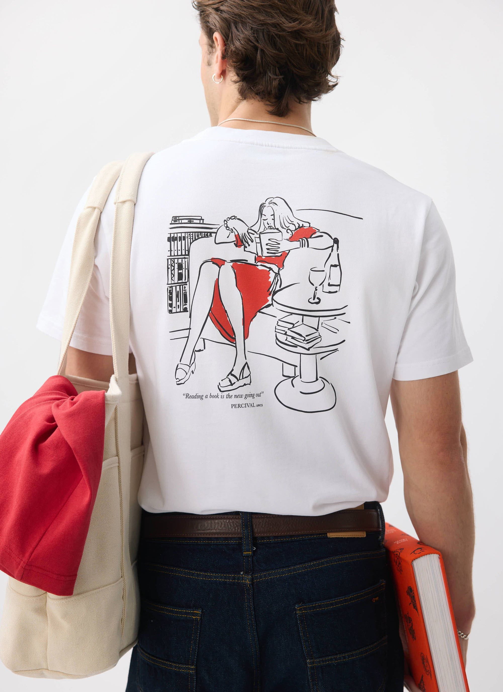 A model seen from behind wearing the Percival Greatest Bookshop t-shirt, showing the 'reading' illustration on the back.