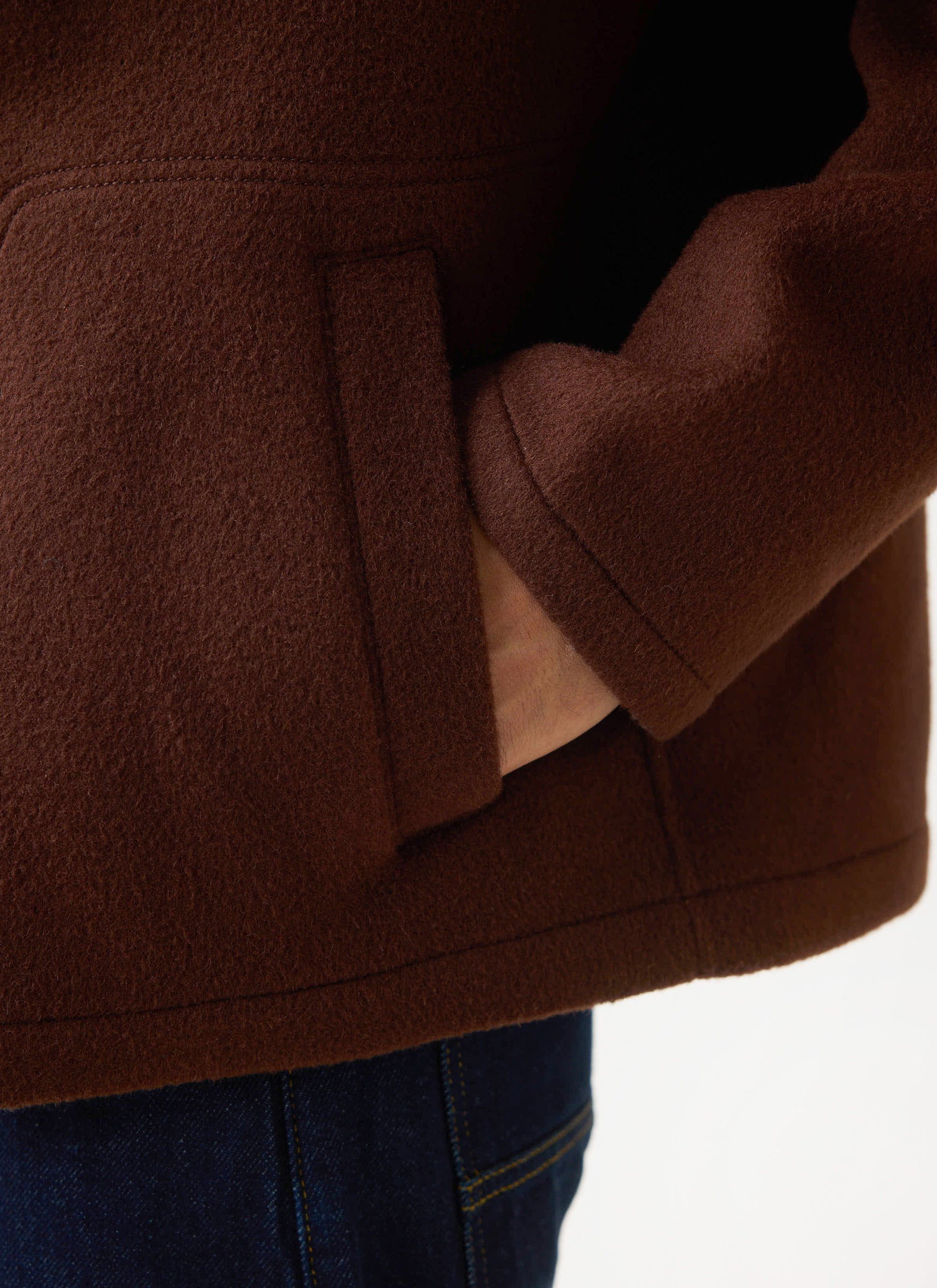 A close-up on the side pocket of the Guinness x Percival wool jacket in espresso, showcasing the rich texture of the fabric.