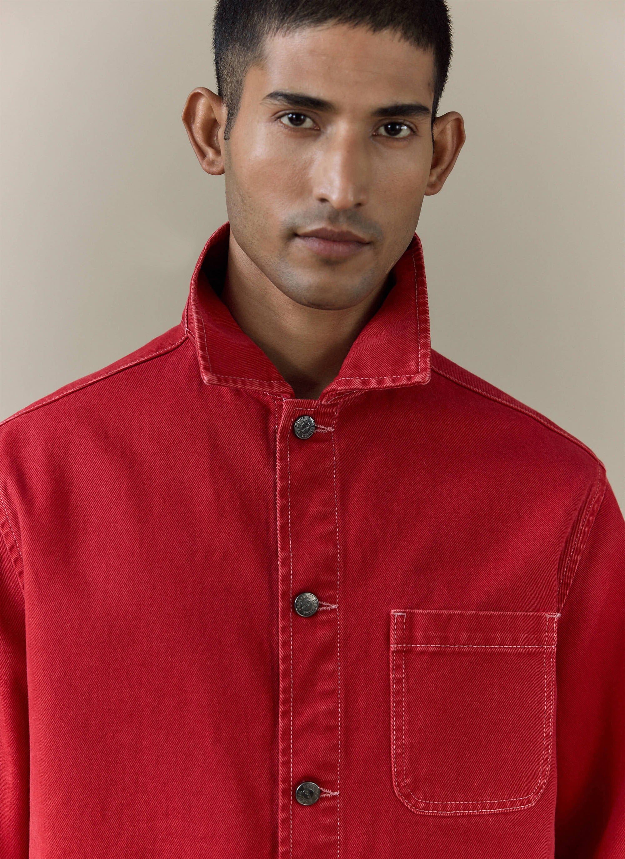 Close-up of the Percival red cotton canvas Vintage Wash Oliver Chore Jacket with white contrast stitching.
