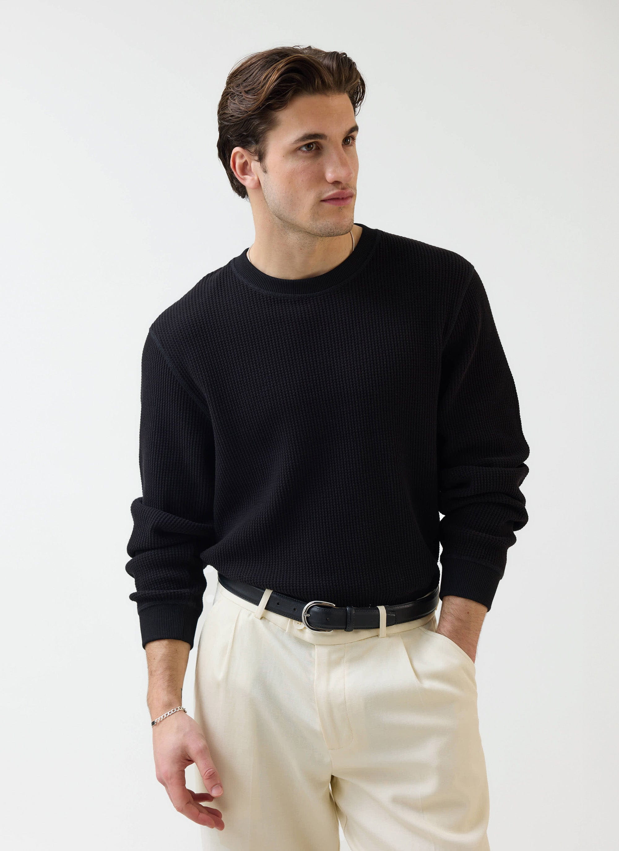 A model wears the Percival black Waffle Long Sleeve T-Shirt, styled with cream trousers against a white studio background.