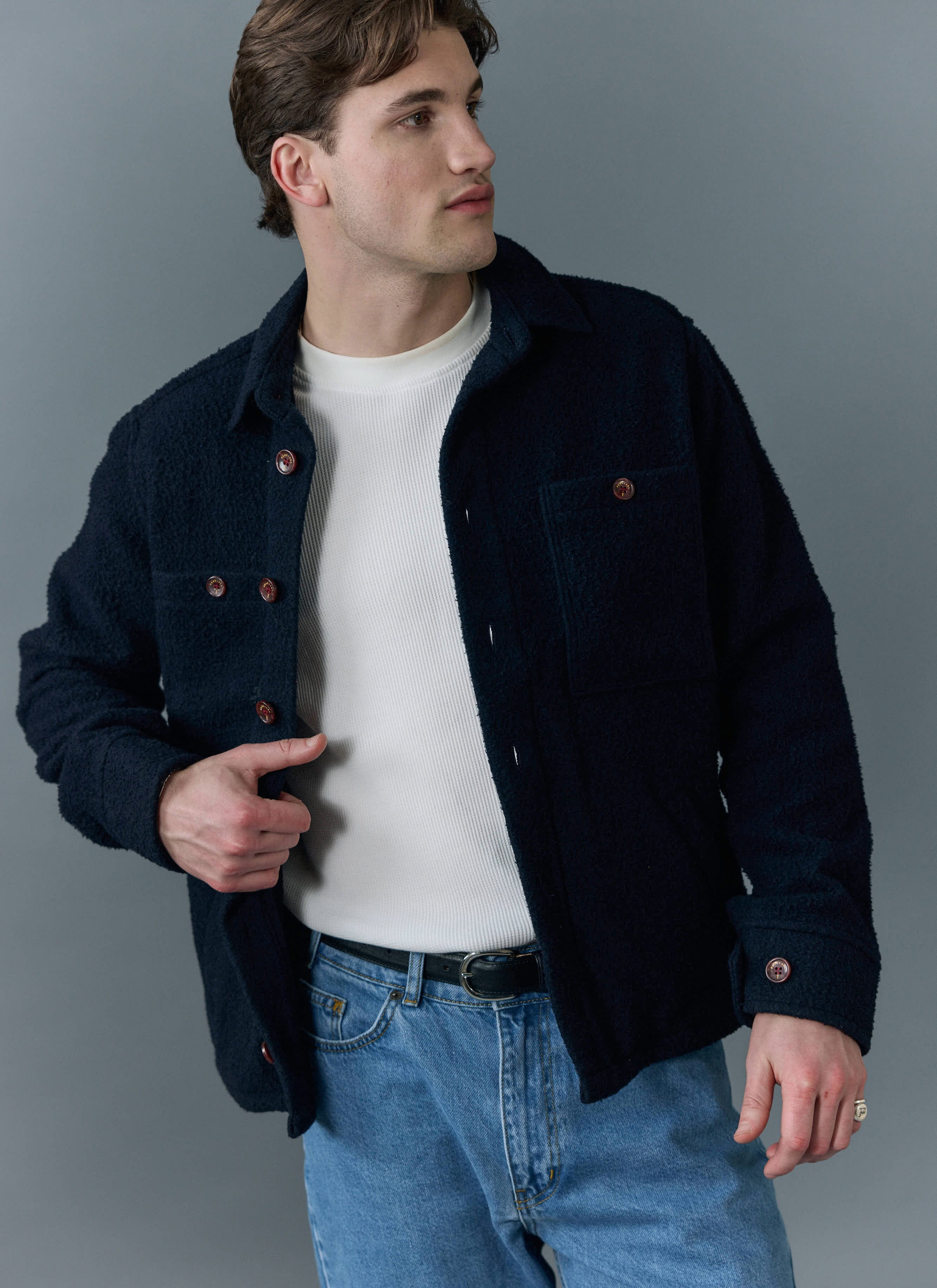 A model wears the Percival navy Blanket Overshirt in Casentino wool, styled with a white t-shirt and blue jeans.