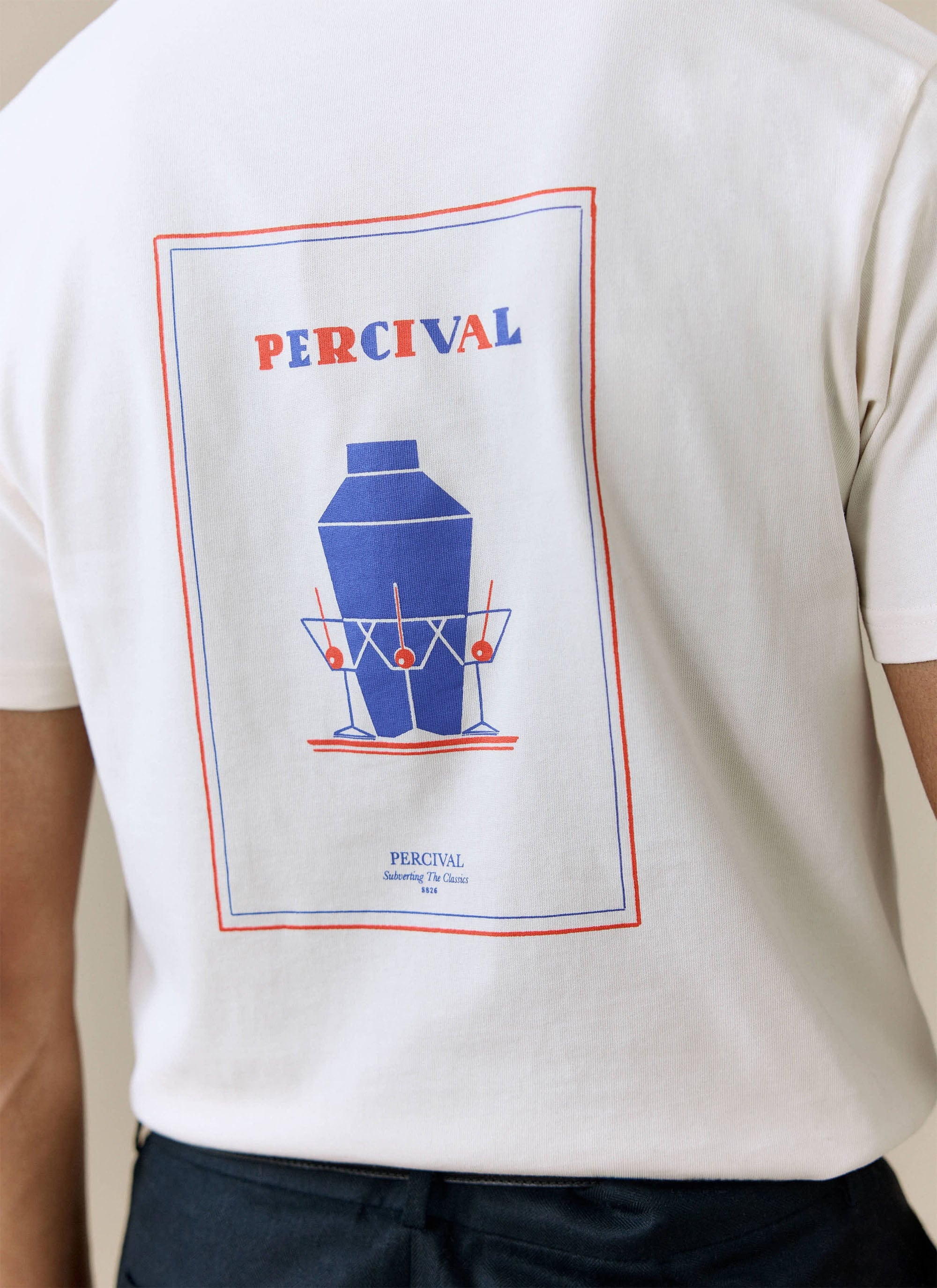 A close-up on the back of a model wearing the ecru Percival Mixologist Martini T-shirt, showing the cocktail print.