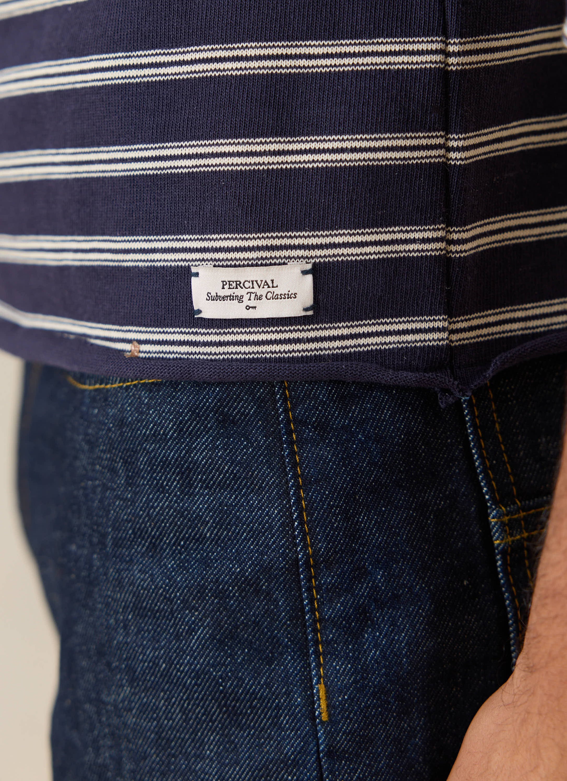 Close-up of the Percival Arlo Breton T-shirt in navy stripe, highlighting the woven label and raw hem.