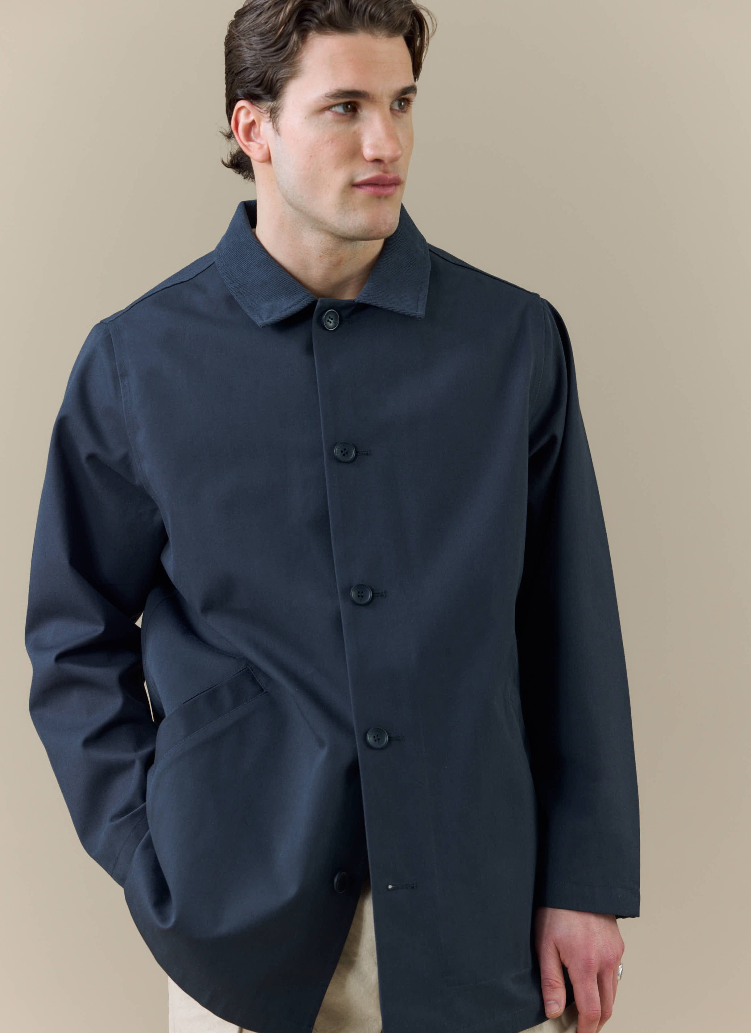 A model wears the Sherlock Trench from the Percival x Brighton & Hove Albion F.C. collection in a midnight colour.