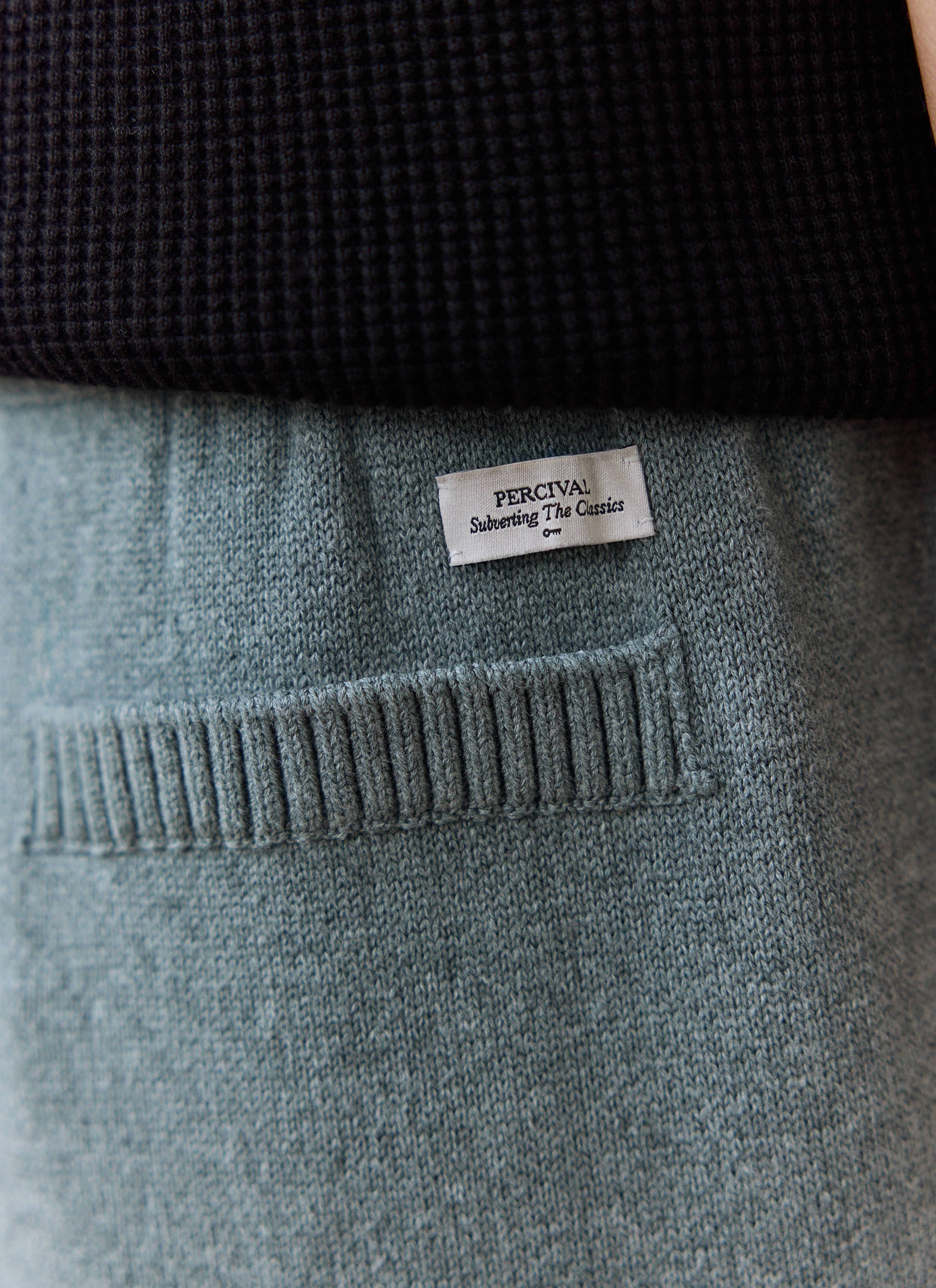 Close-up shot of the Percival label and ribbed back pocket detail on the grey Chronicle Knitted Straight Leg Trackpant.