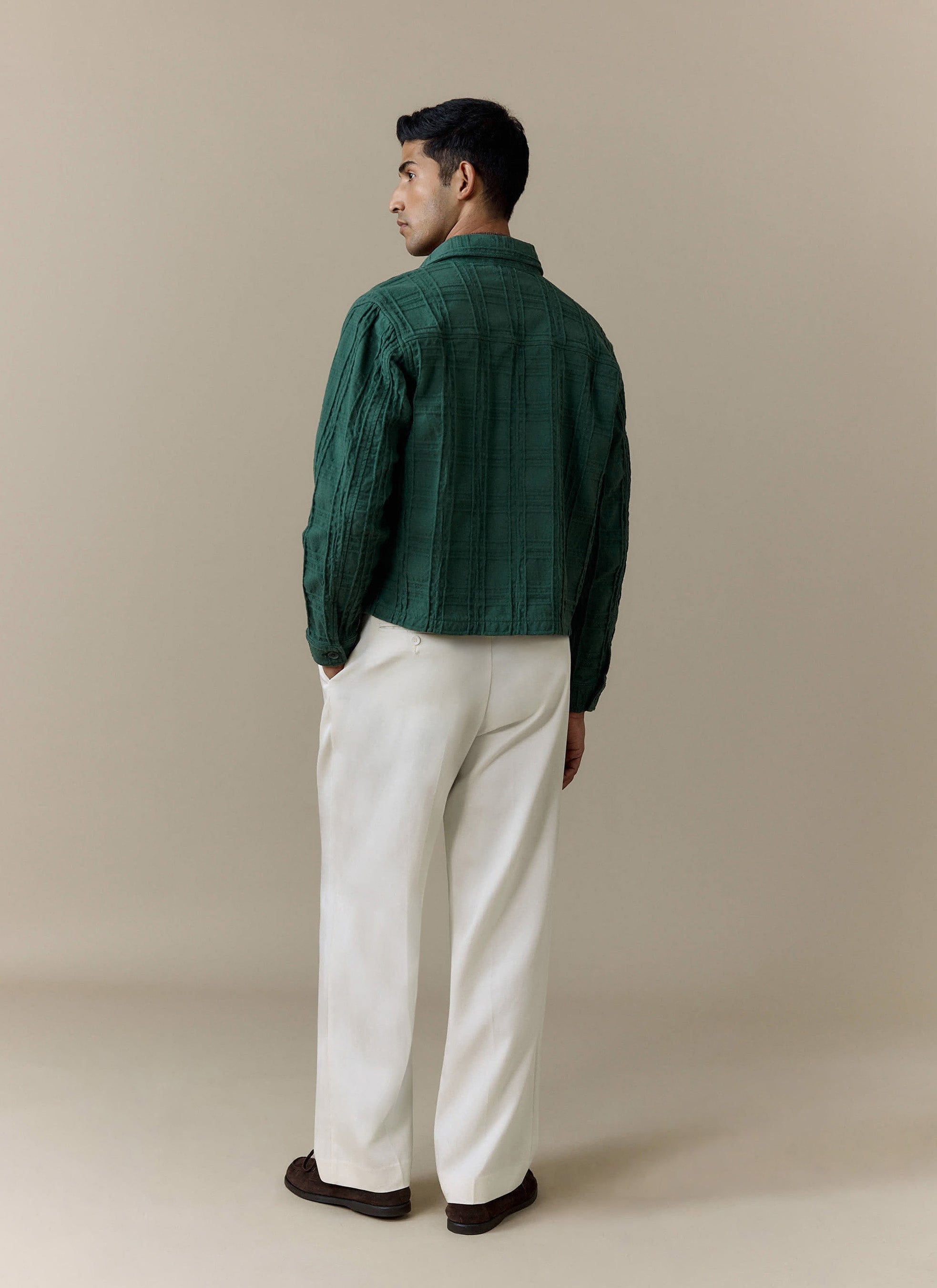 Back view of a model wearing the Percival Canyon Heavyweight Overshirt in forest green, styled with white trousers.