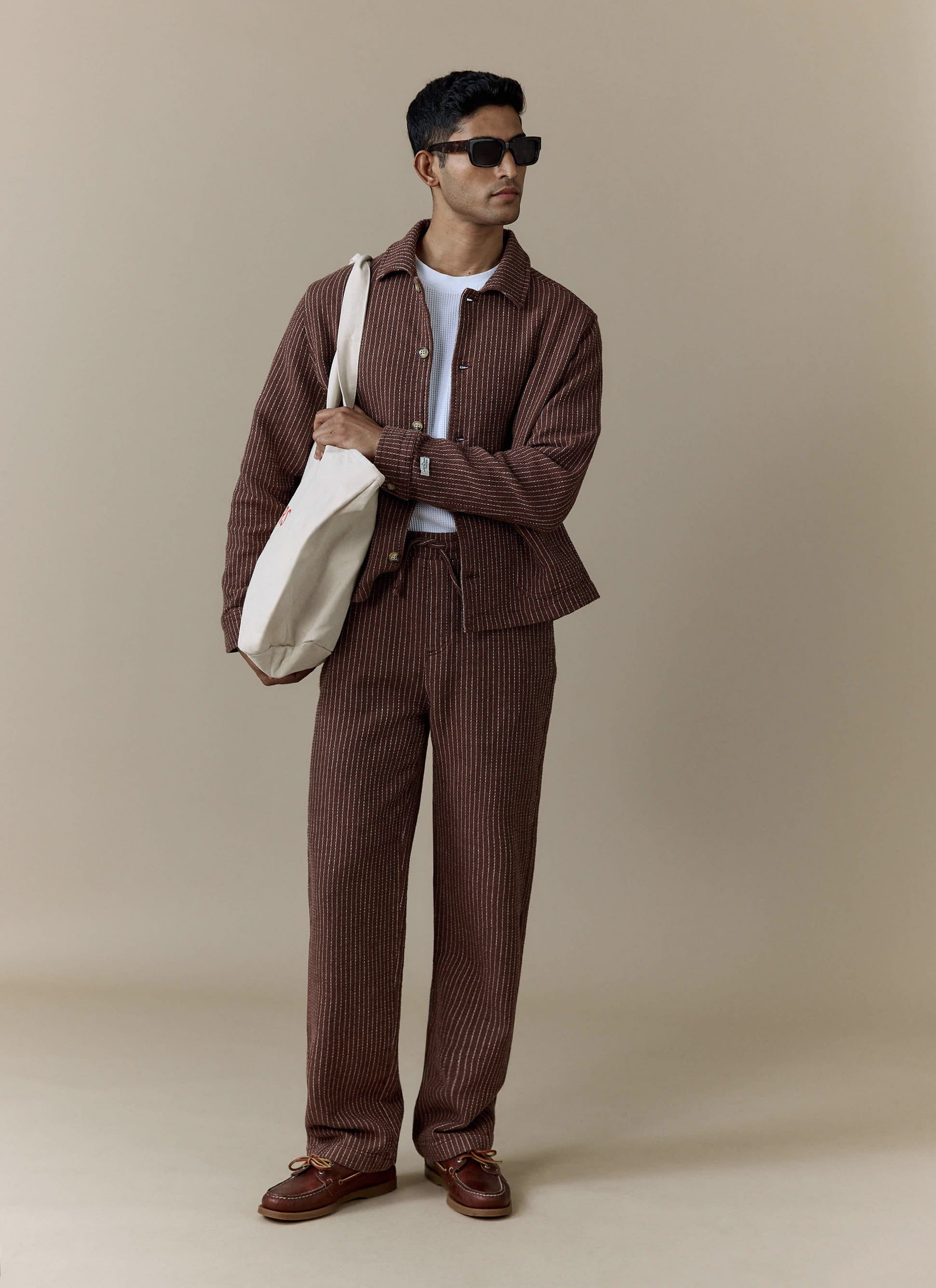Brown pinstriped Percival Sorrento wide leg trousers in a linen blend, worn by a model as part of a matching co-ord.