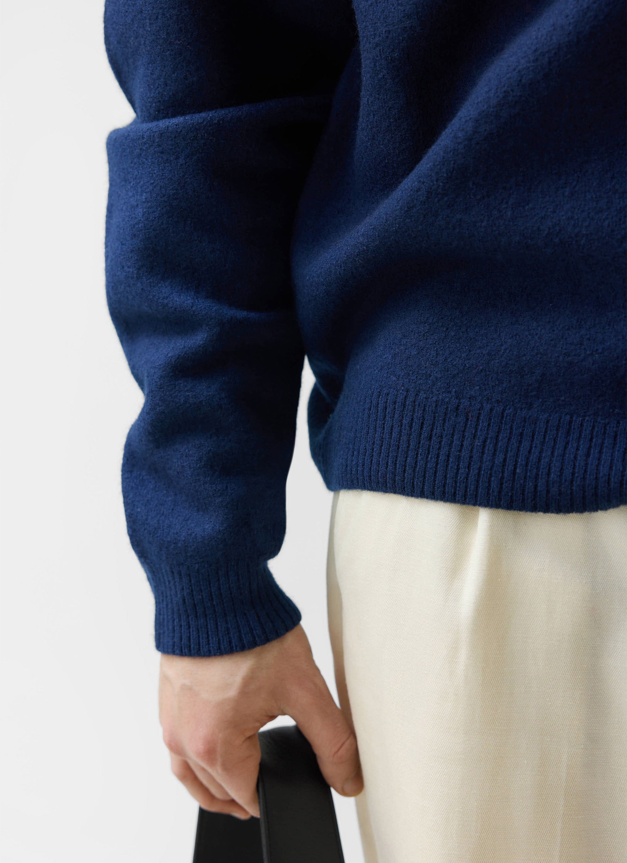 A close-up of the Percival Felted Regular Jumper in navy, showing the soft merino wool texture and ribbed details.