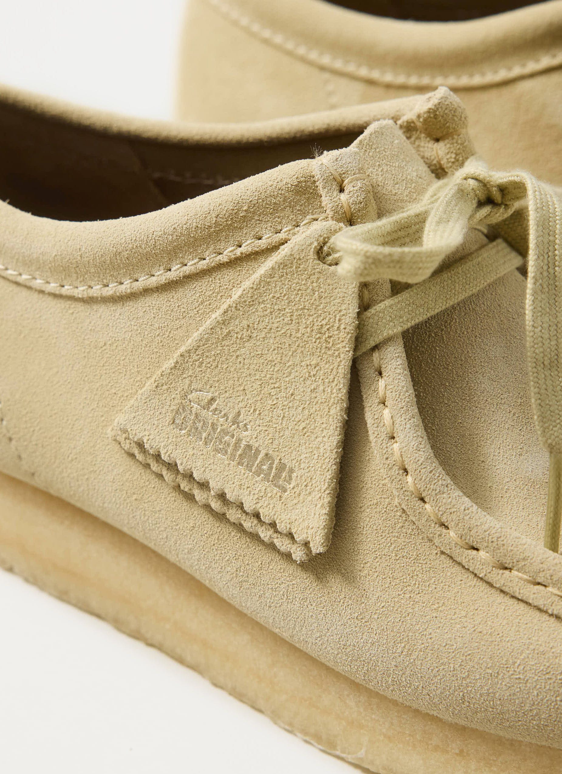 Close up of the Percival x Clarks Originals Wallabee shoe in maple suede showing the branded tag and stitching details.