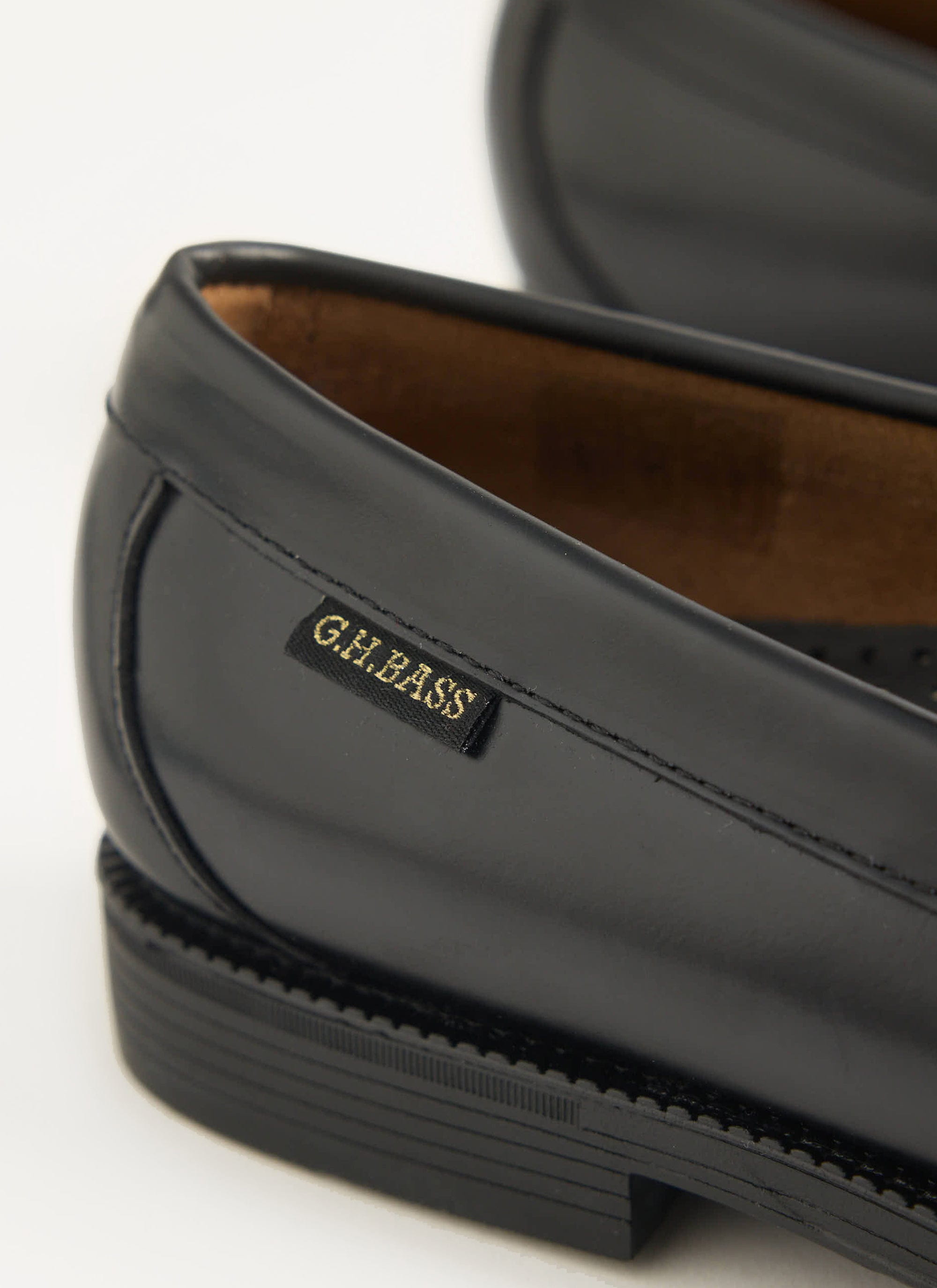 Close-up detail of the G.H. Bass logo on the black leather Larson Flag Weejuns loafers, available at Percival.
