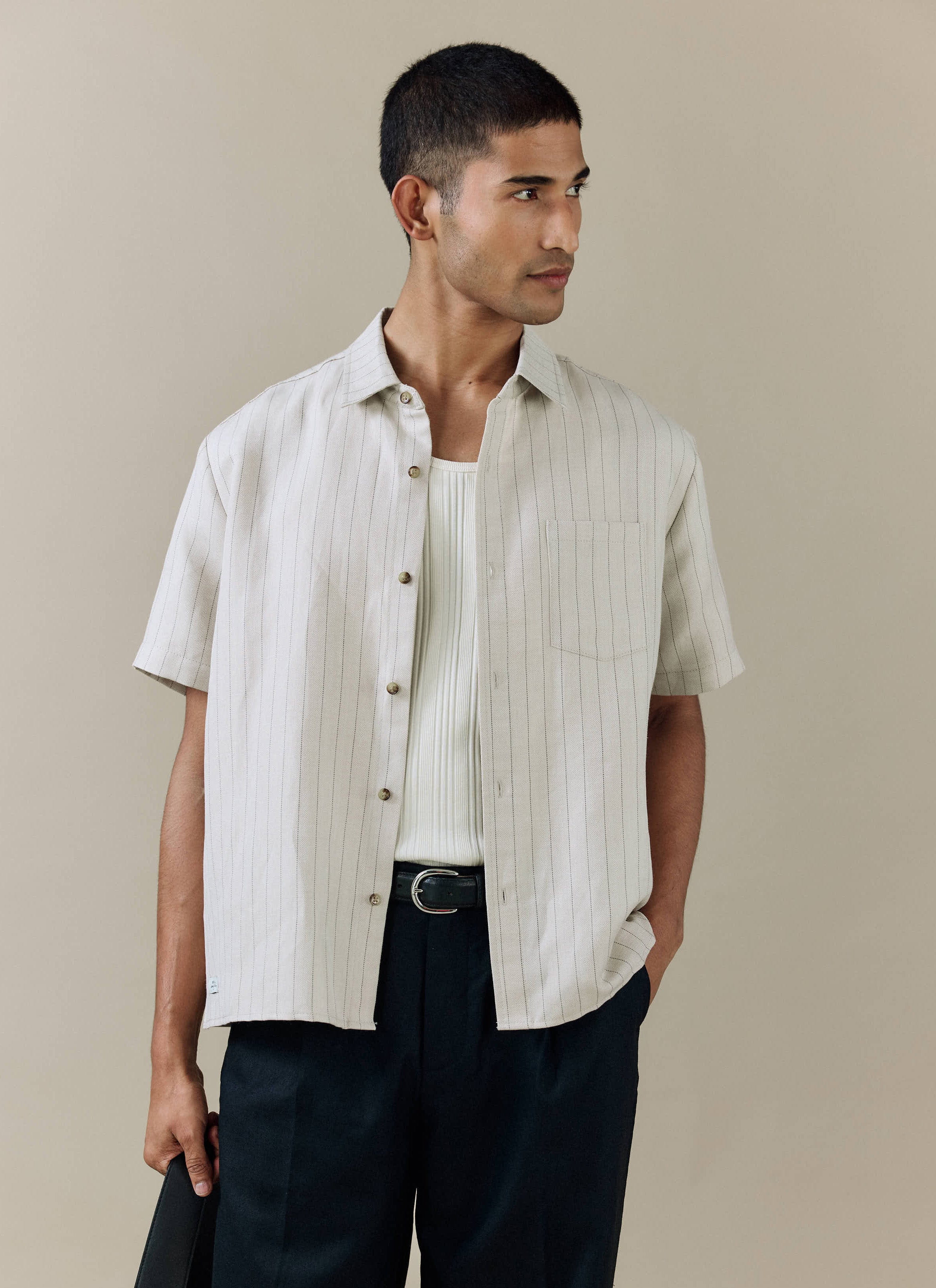 Percival Striped Boxy Shirt in cream linen blend with fine pinstripes, worn open over a white vest for a summer look.
