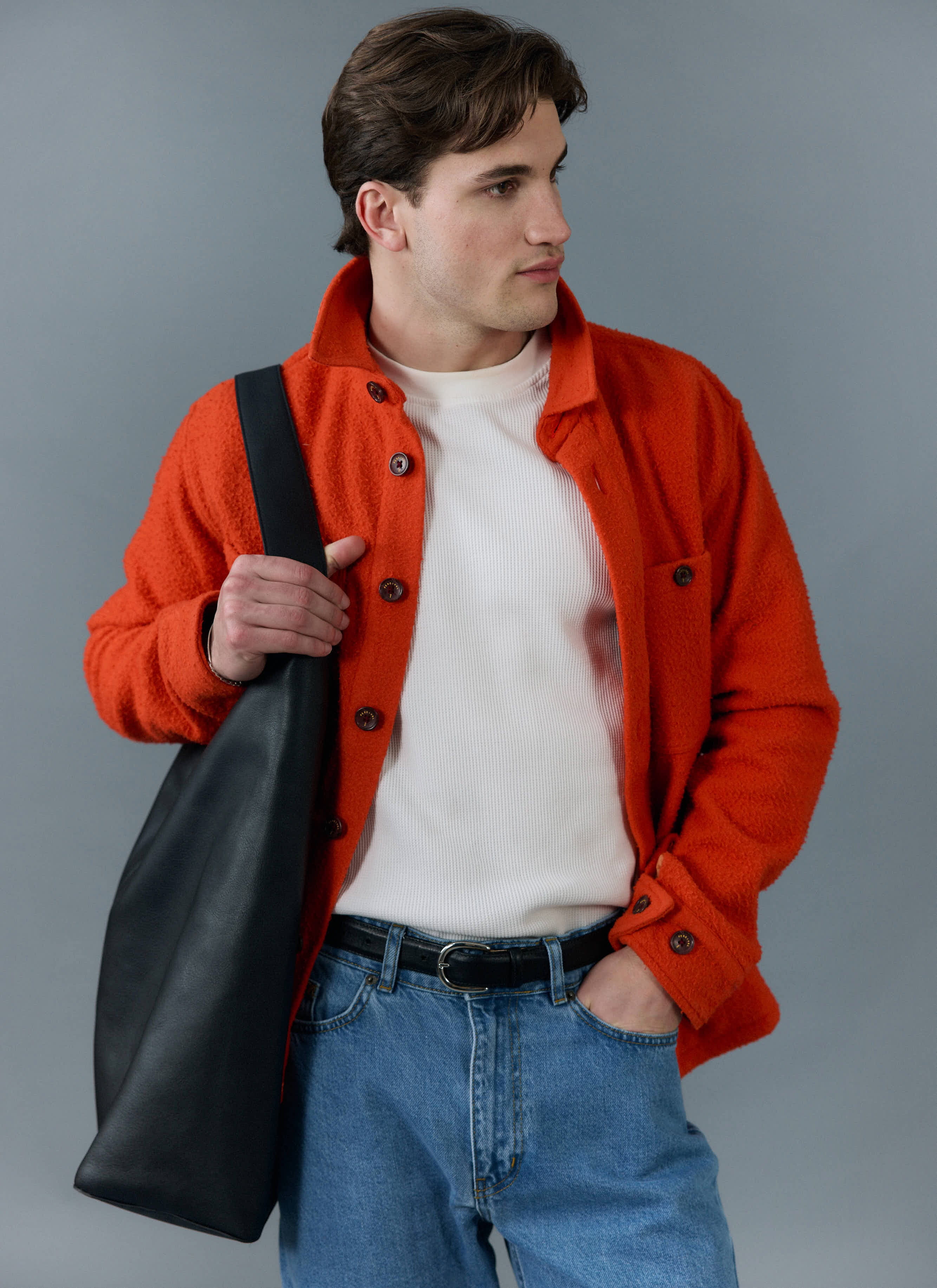 Model styles the Percival orange Casentino wool overshirt with a white top, blue jeans and a black tote bag.