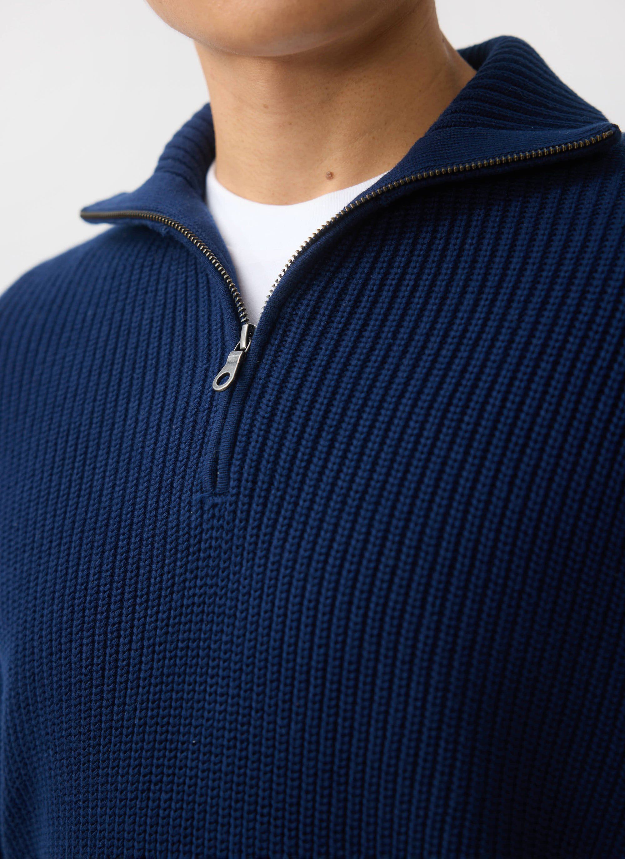 Close up of the Percival Meyer Quarter Zip jumper in blue cotton, showing the chunky ribbed texture and zip collar.