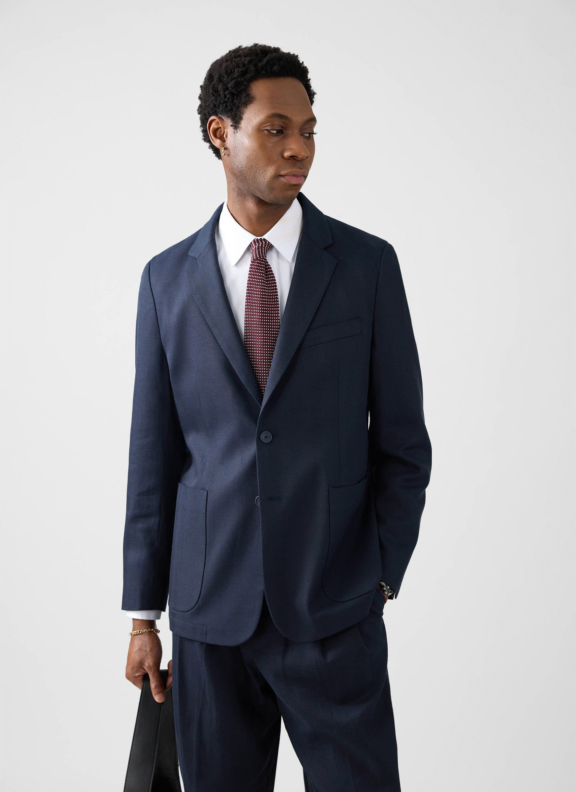 A model wears the Percival Lyocell Regular Blazer in navy, styled with a white shirt and patterned red tie.