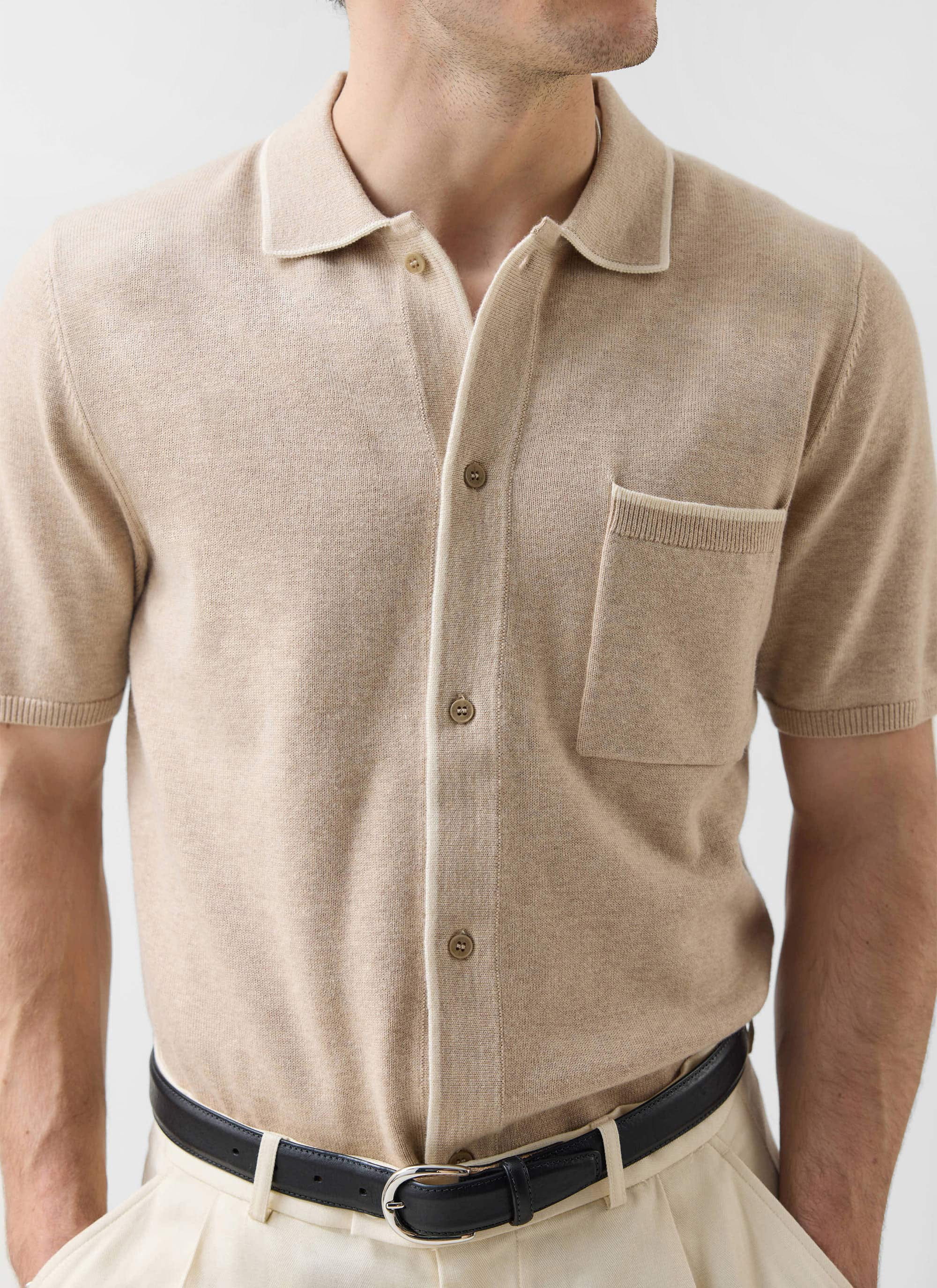 A close-up of a model wearing the Percival Contrast Trim Regular Knitted Shirt in beige against a plain background.
