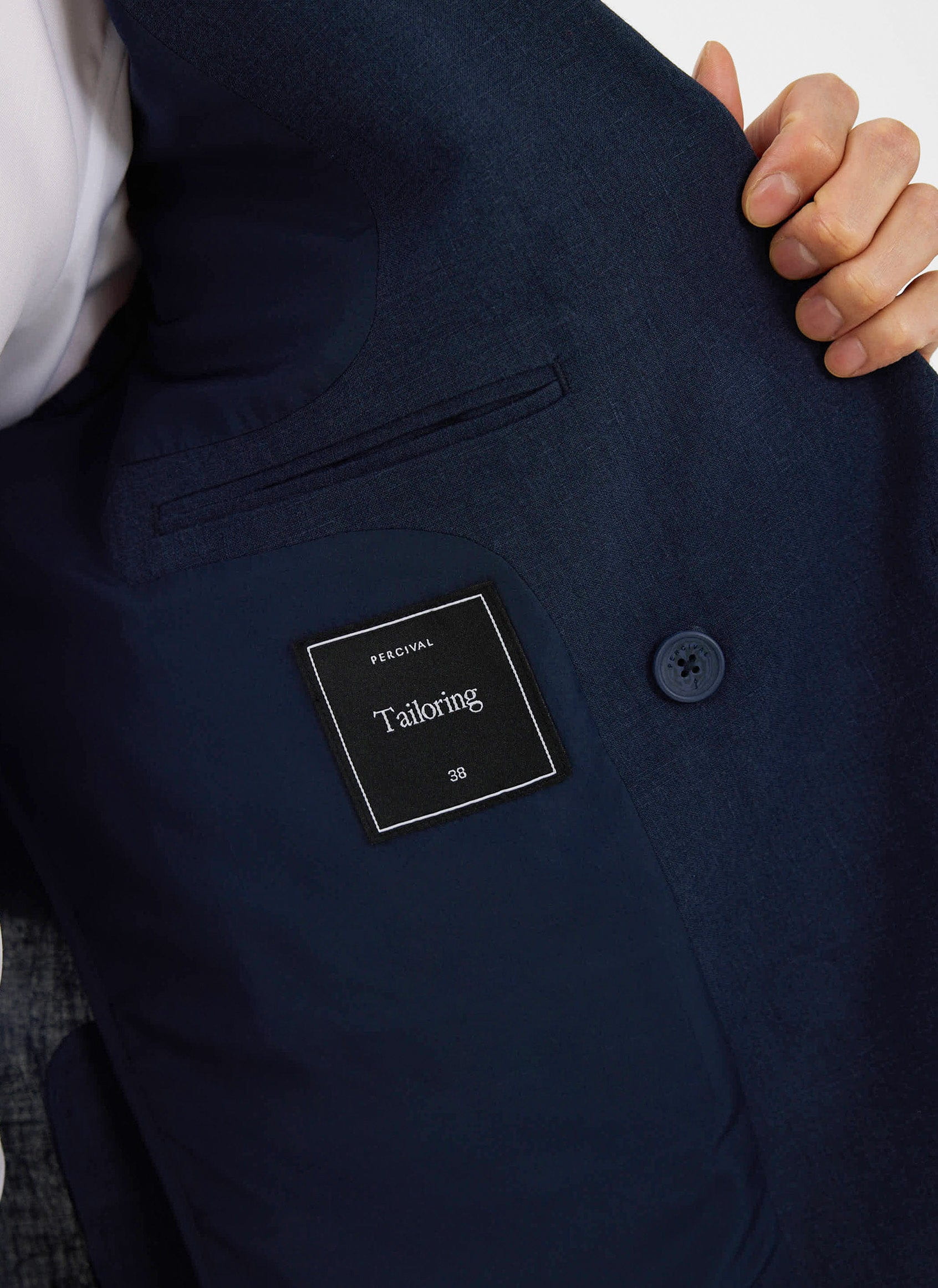 Close-up of the inside of the Percival Clifton Double Breasted Blazer in navy linen, showing the tailoring label.