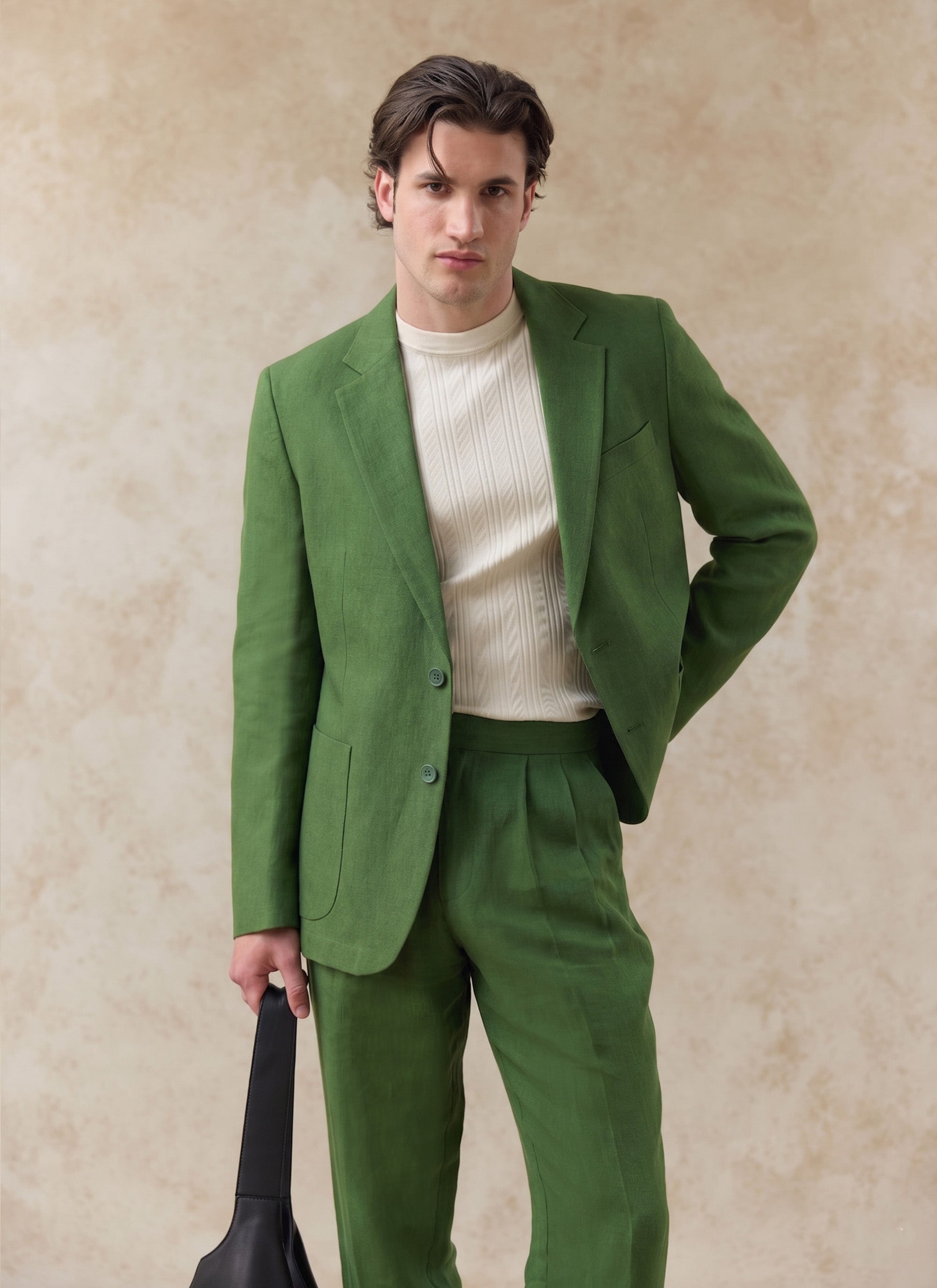 Percival forest green tailored linen blazer and matching trousers worn with a cream textured top.