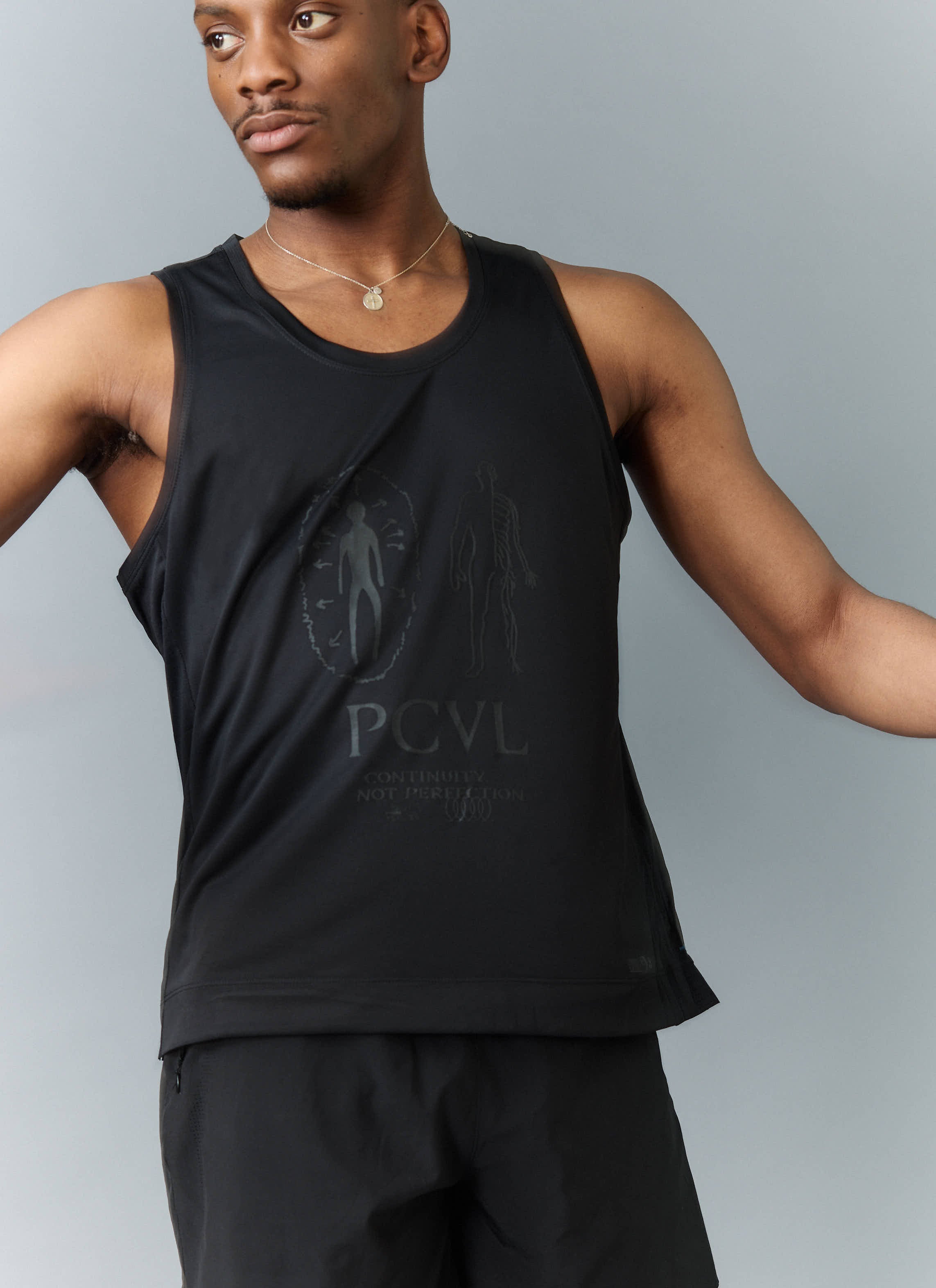 A model wears the Percival PCVL Performance Vest in black, showing the tonal anatomical graphic on the chest.