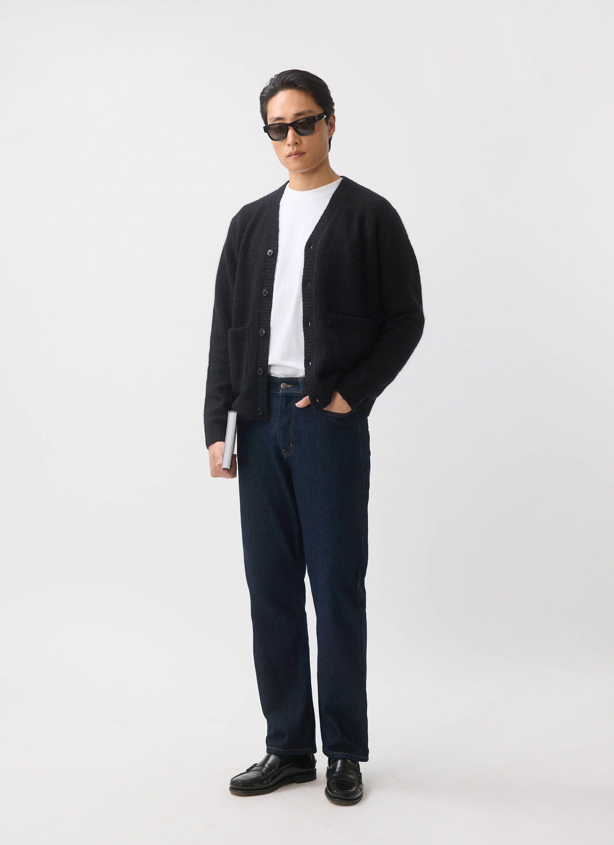 A model wears the black mohair White Glove Cardigan from Percival with a white tee, dark jeans, and sunglasses.