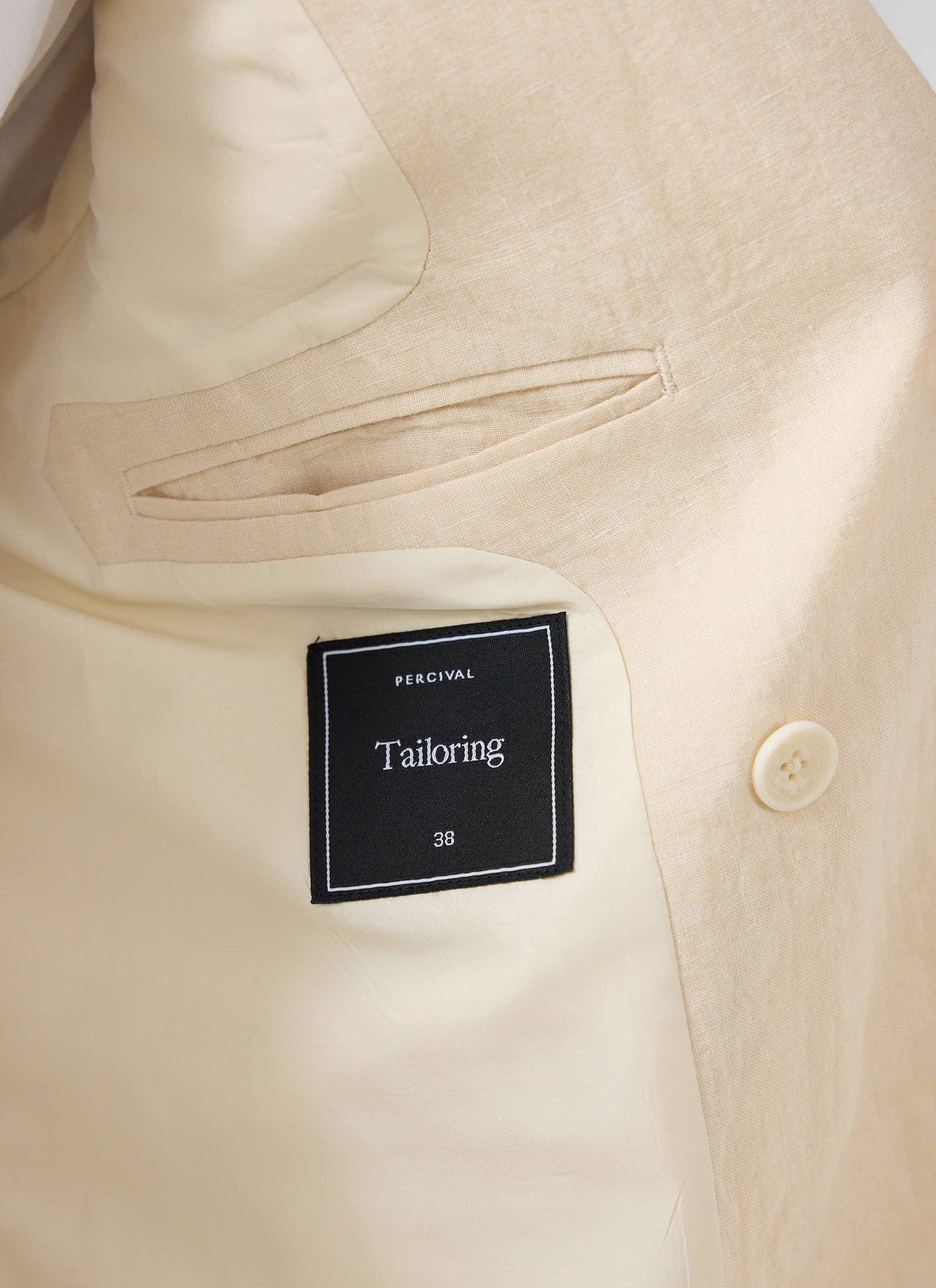 Internal view of the Percival Clifton Double Breasted Blazer in cream linen, detailing the branded 'Tailoring' label.