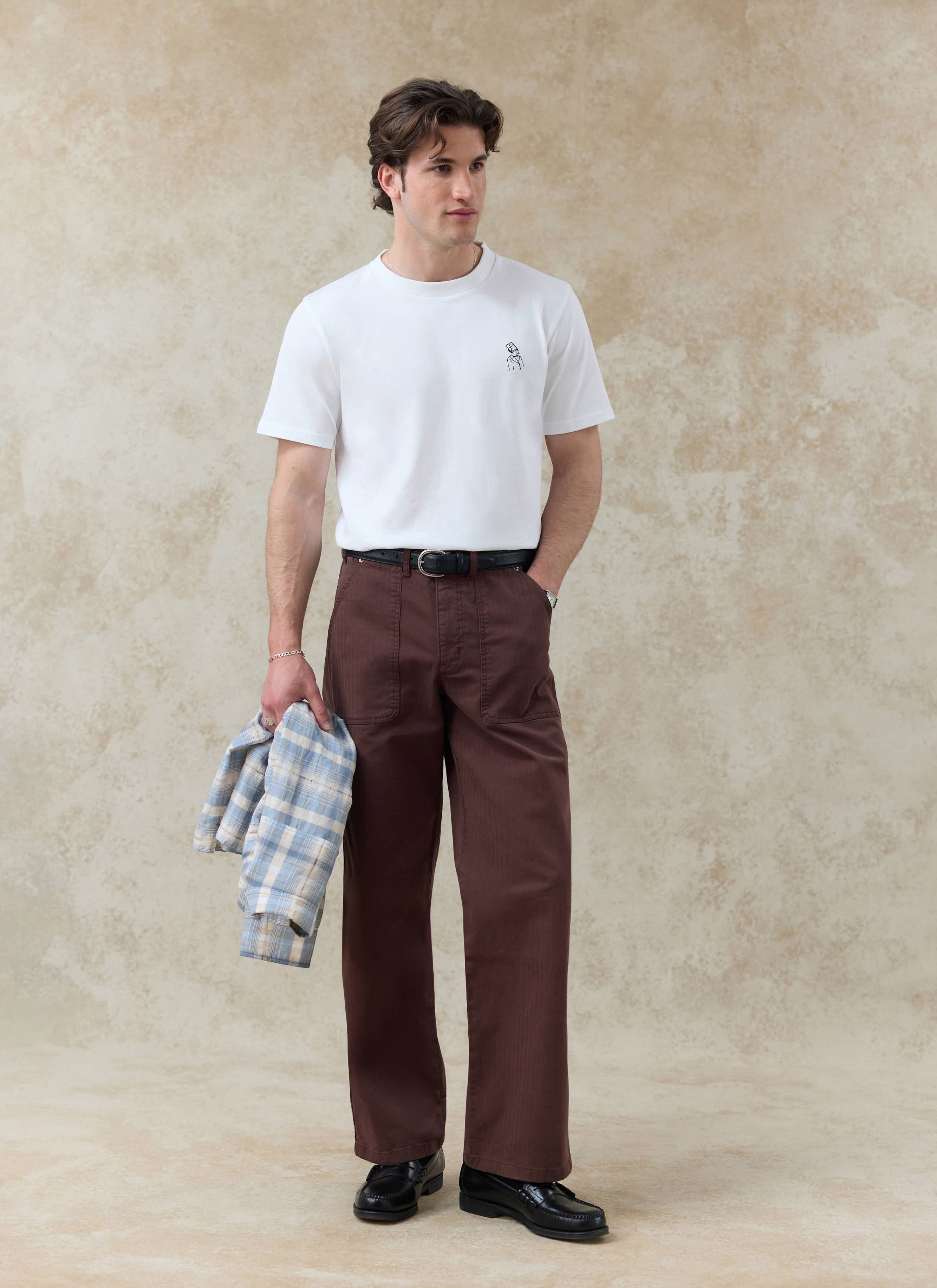 White Percival Robinson organic cotton t-shirt featuring a small chest embroidery, styled with brown trousers.