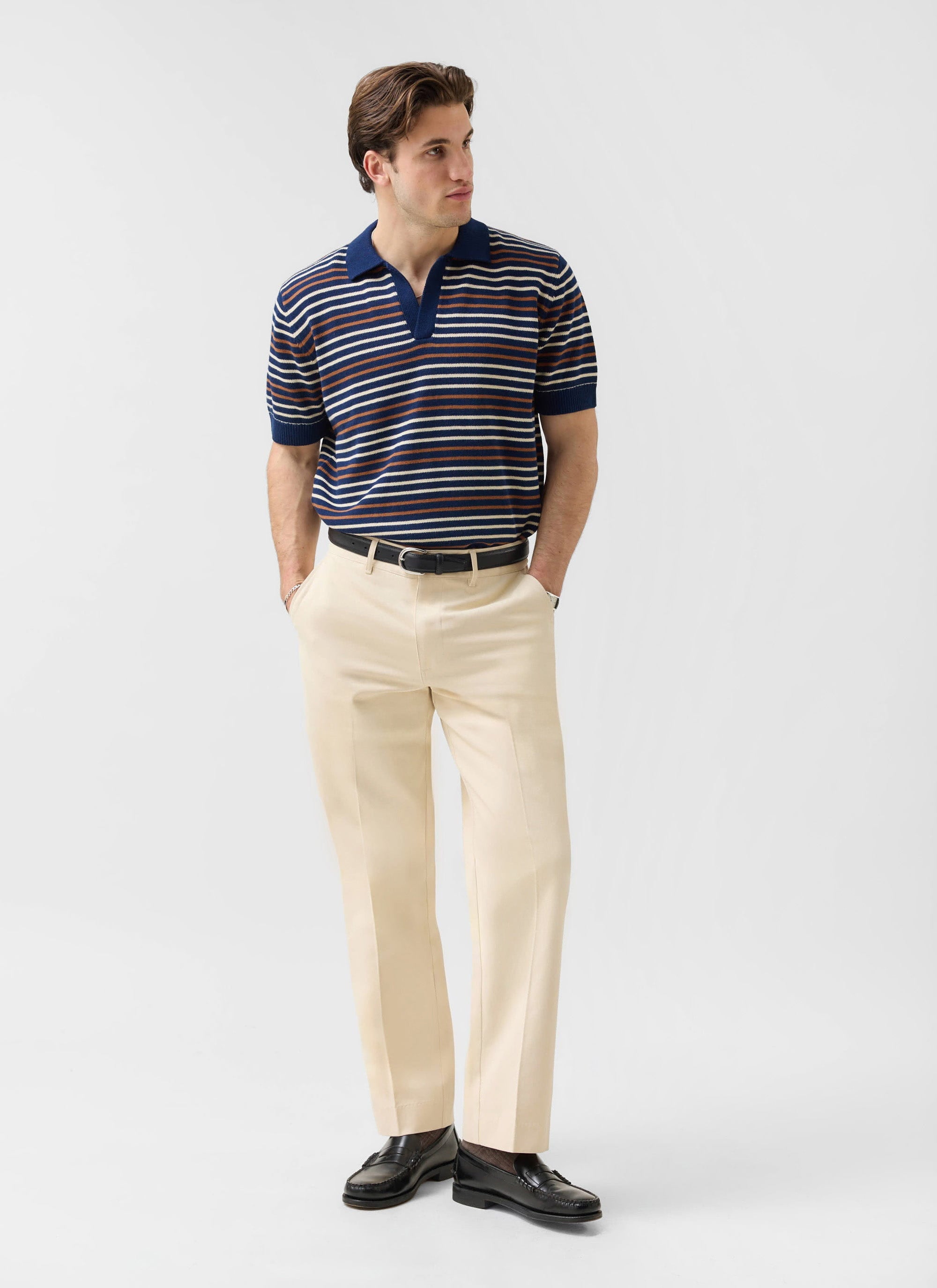 A model wears the Percival Straight Leg Chinos in ecru, styled with a striped knit polo and black loafers.