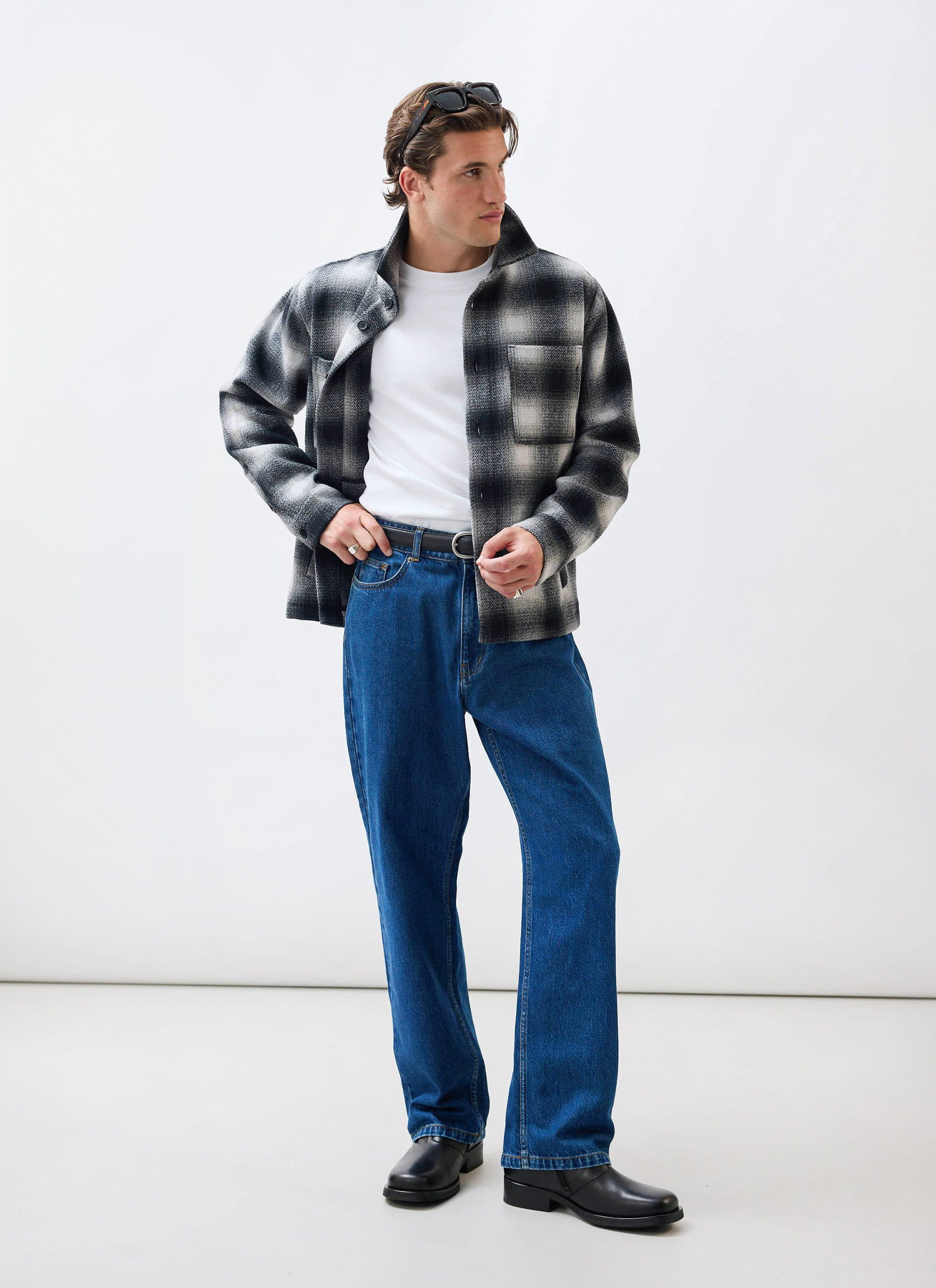 A model wears the Percival Check Overshirt in grey, styled with a white t-shirt and blue jeans against a white background.