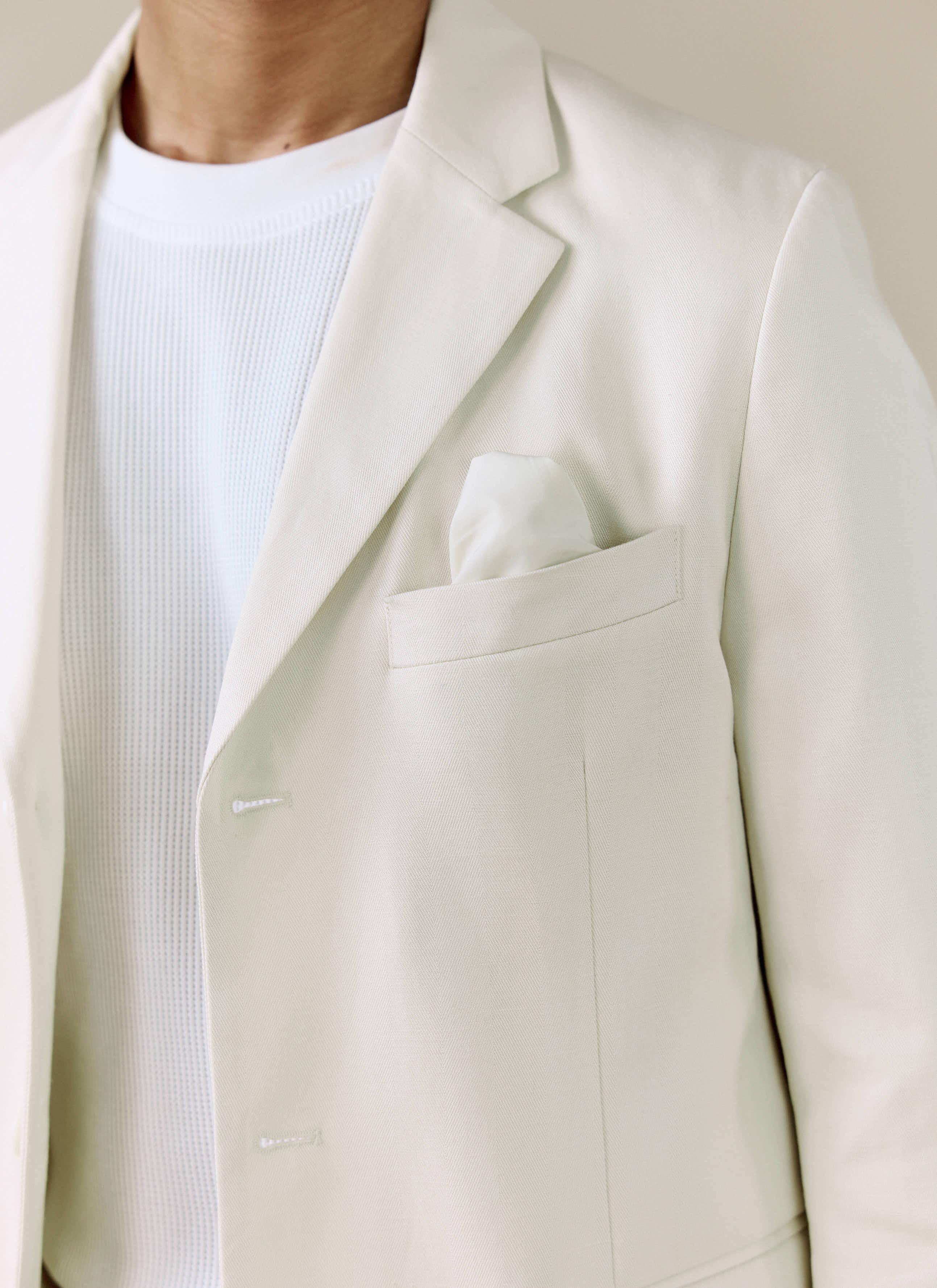 A close-up of the Percival Clifton 3 Button Blazer in cream, showing the lapel detail and pocket square.