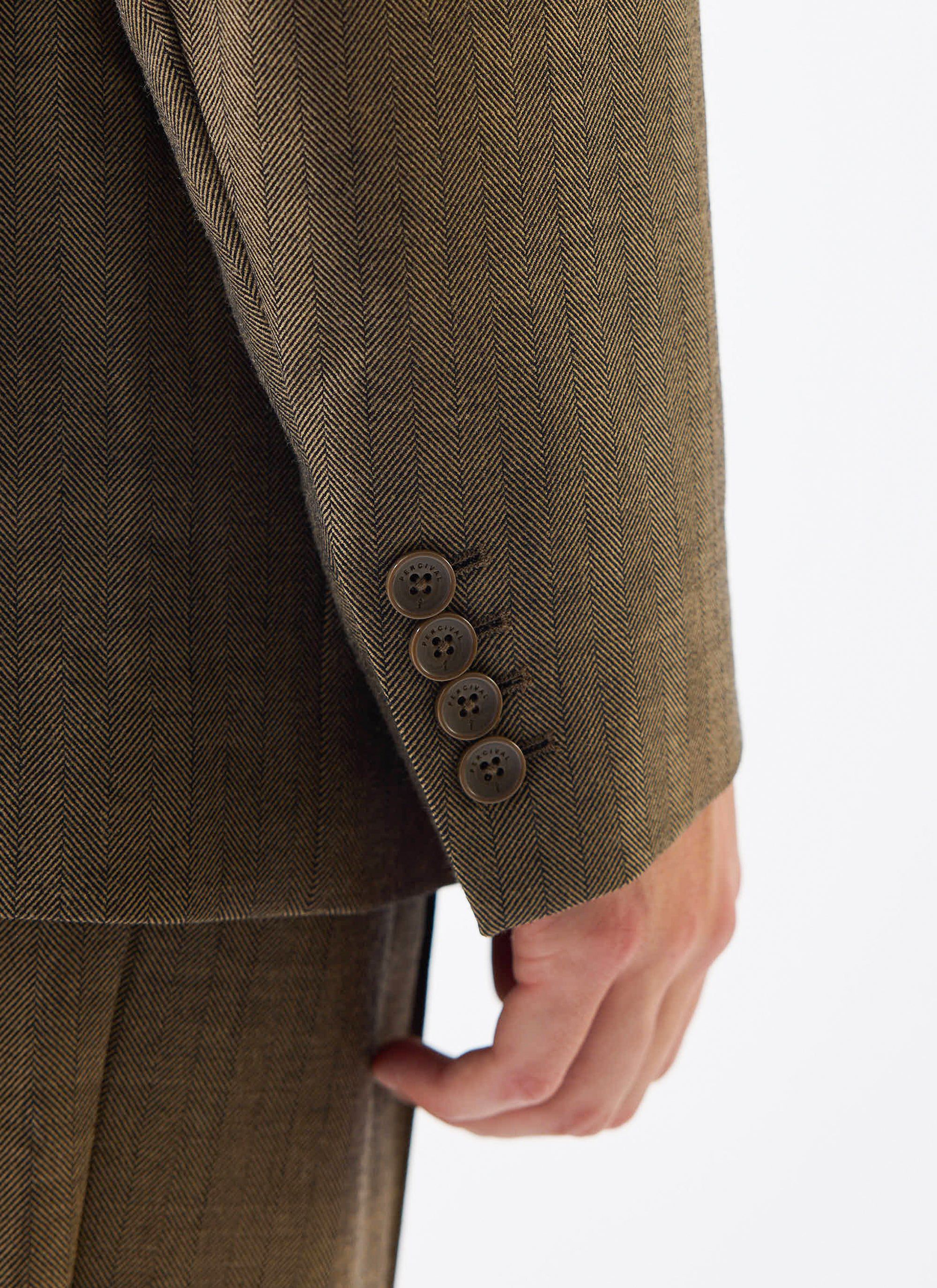 A detailed close-up of the cuff on the Percival Grounds Tailored Blazer, showing the oak herringbone wool and buttons.