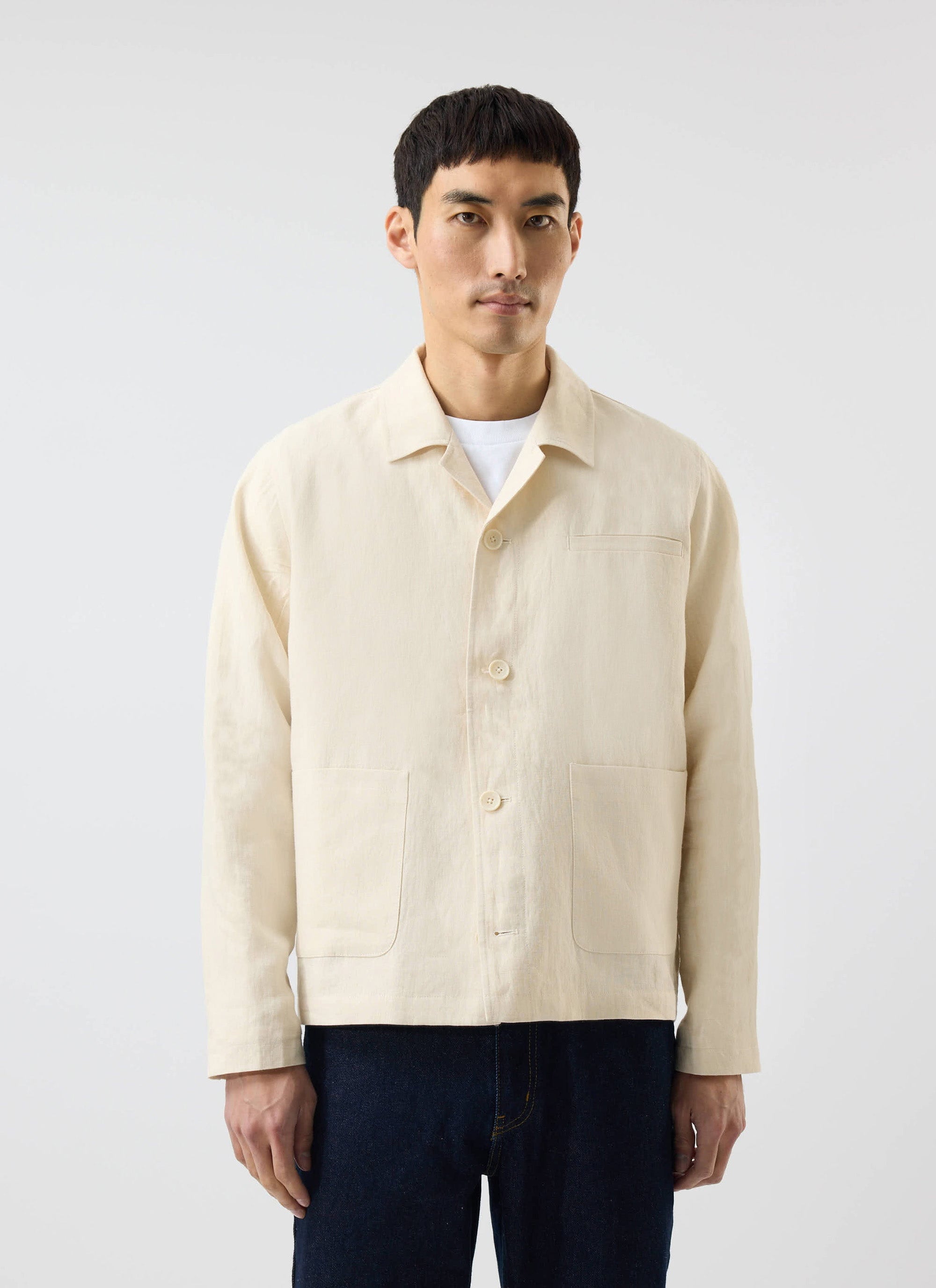 A model wears the Percival Relaxed Linen Overshirt in stone, styled over a white t-shirt against a studio background.