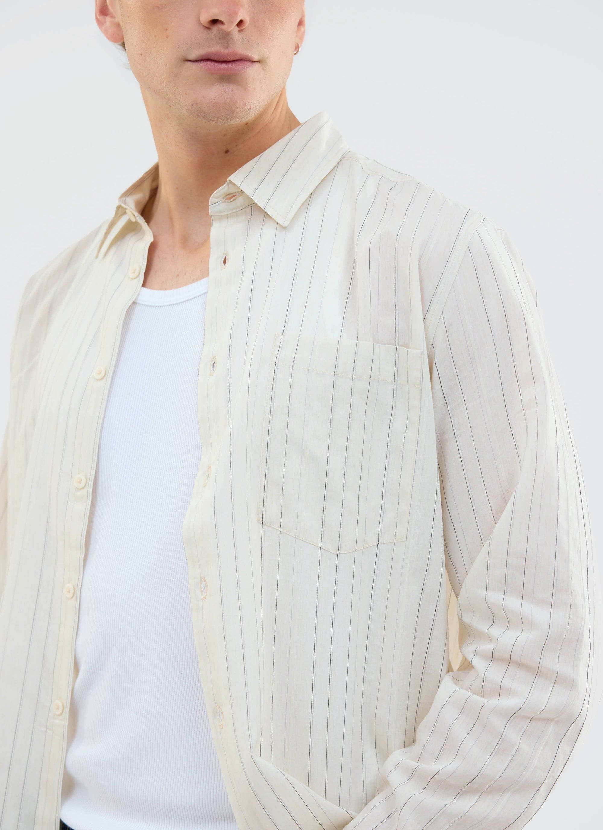 A close-up of a model wearing the Percival Lorenzo Pearce Shirt in ecru, showing the pinstripe detail and chest pocket.