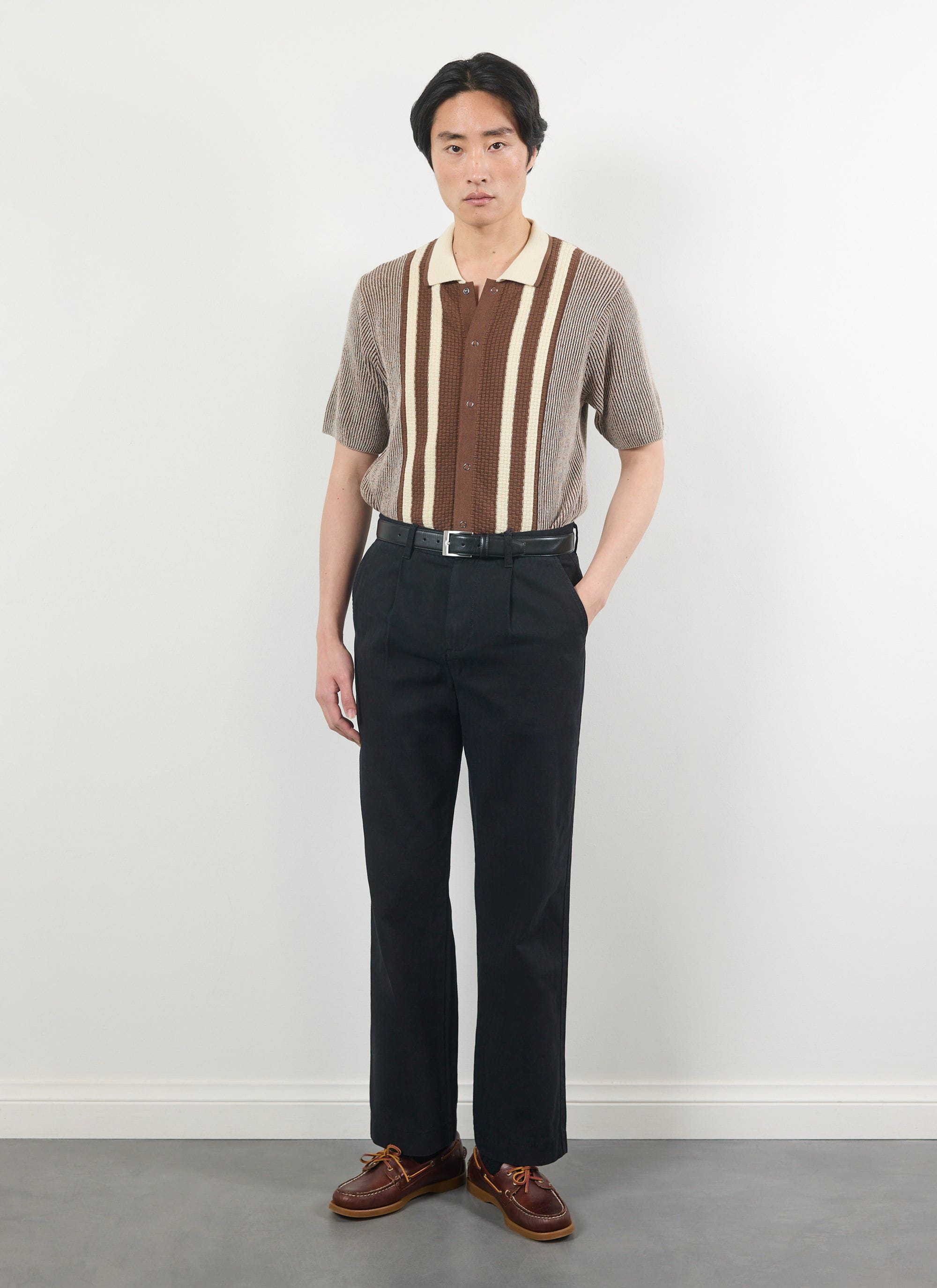 A model wears the Percival Teramo Knitted Polo Shirt in ecru, styled with black trousers against a white background.