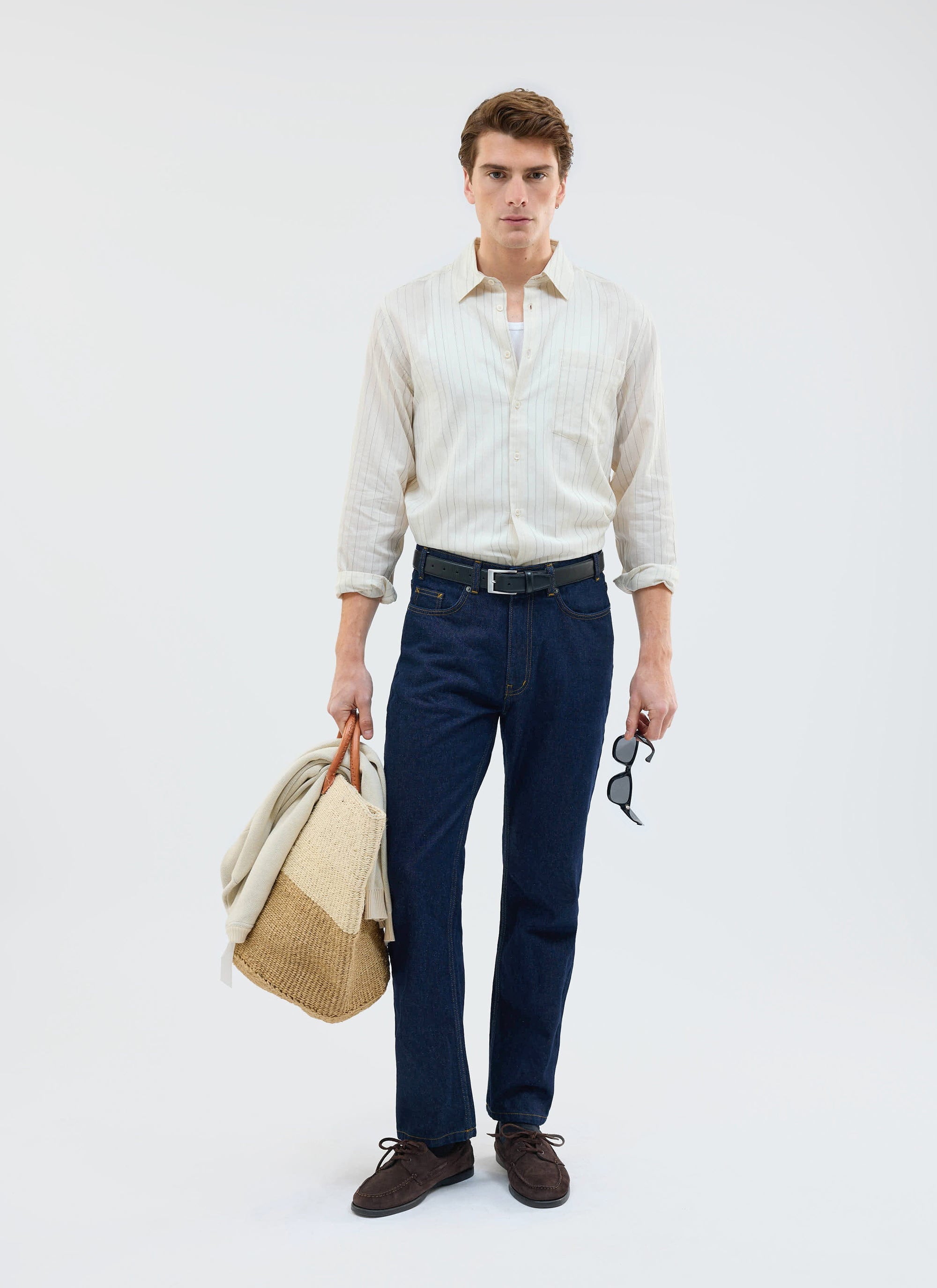 Full-length shot of a model in the Percival Lorenzo Pearce Shirt in ecru, paired with dark denim and summer accessories.