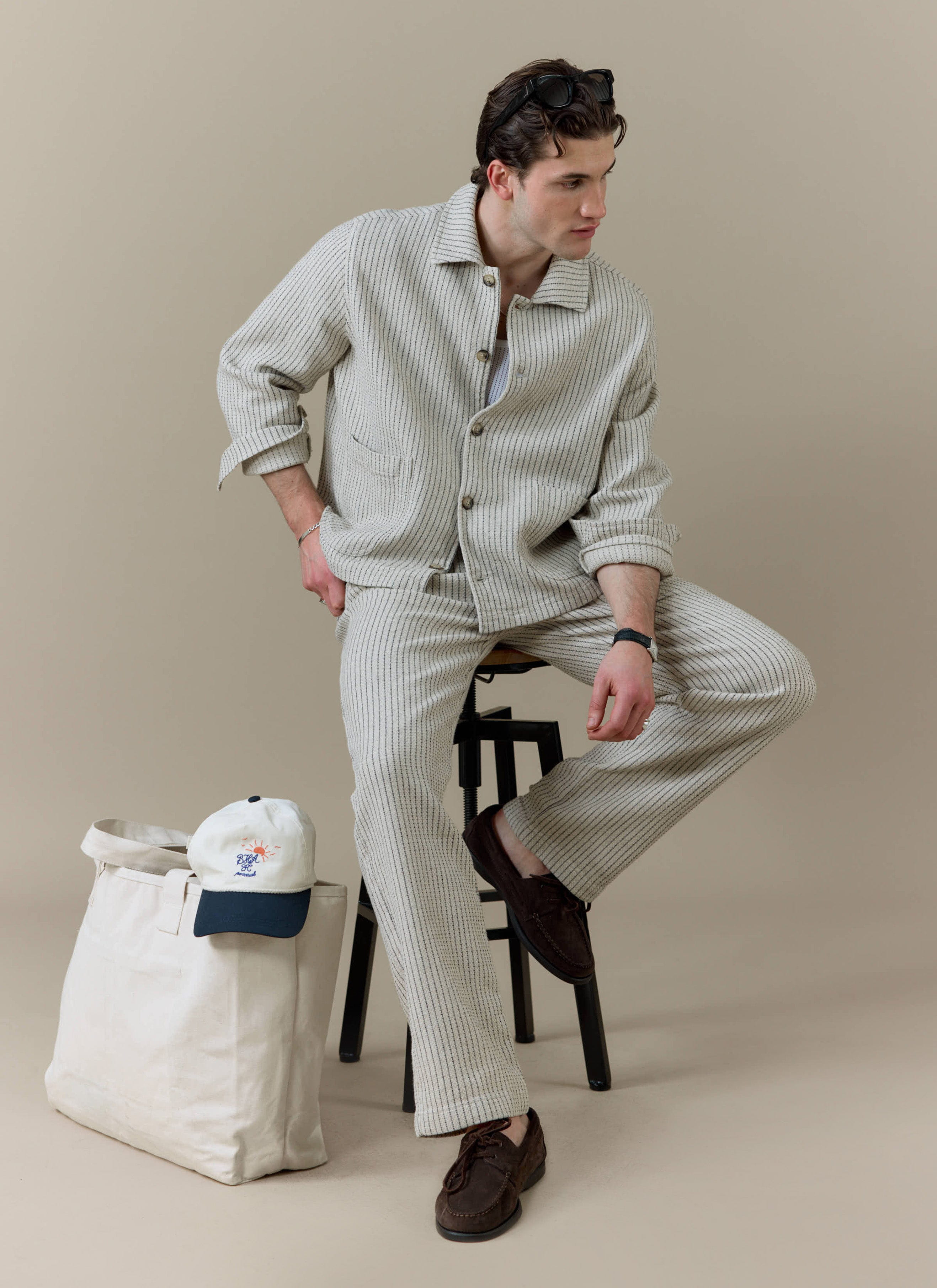 Model wearing the Percival Sorrento Boxy Overshirt and Wide Leg Trousers in cream linen with vertical texture.