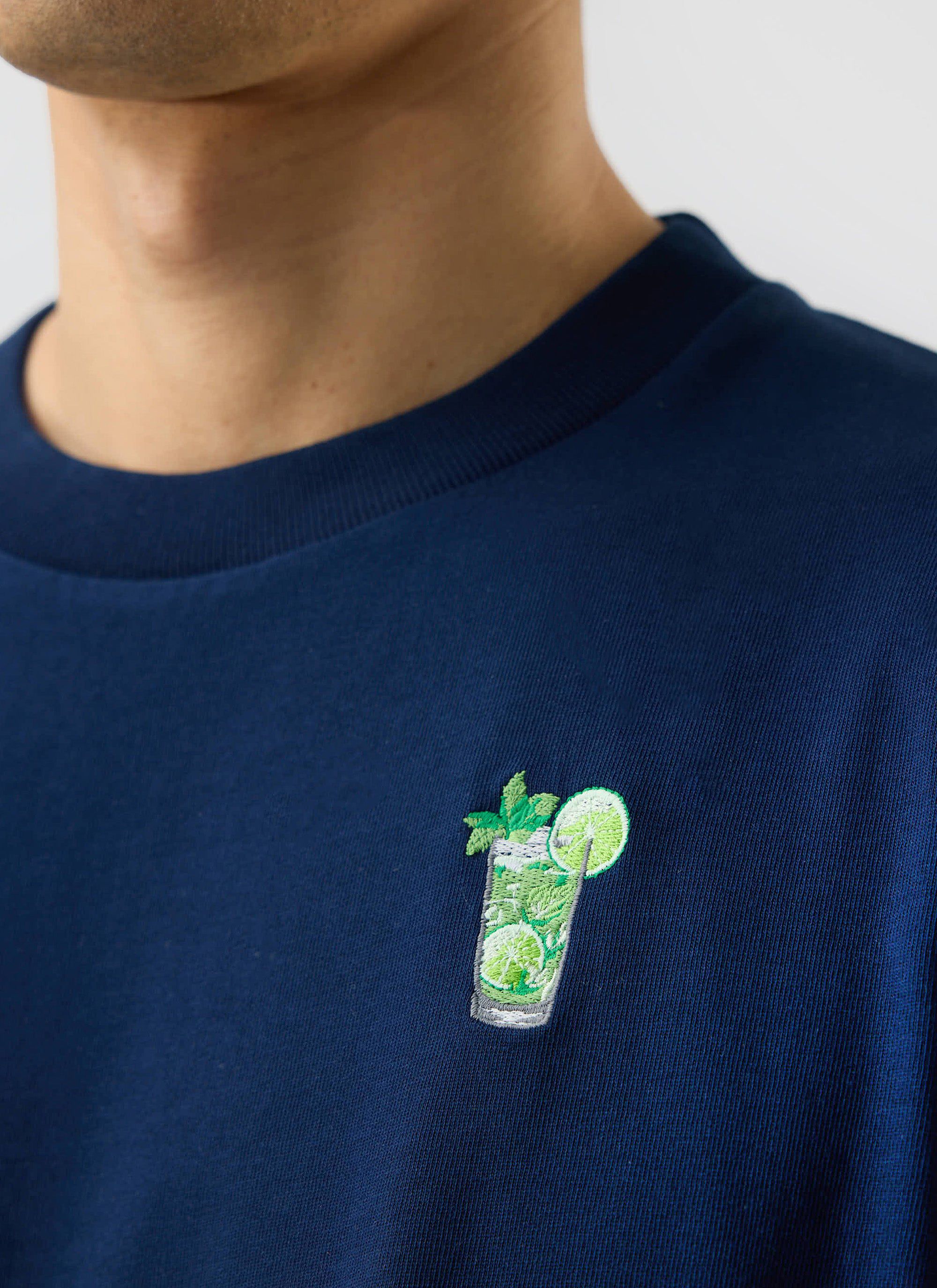 A close-up of the mojito embroidery on the chest of the navy Mojito T Shirt from Percival.