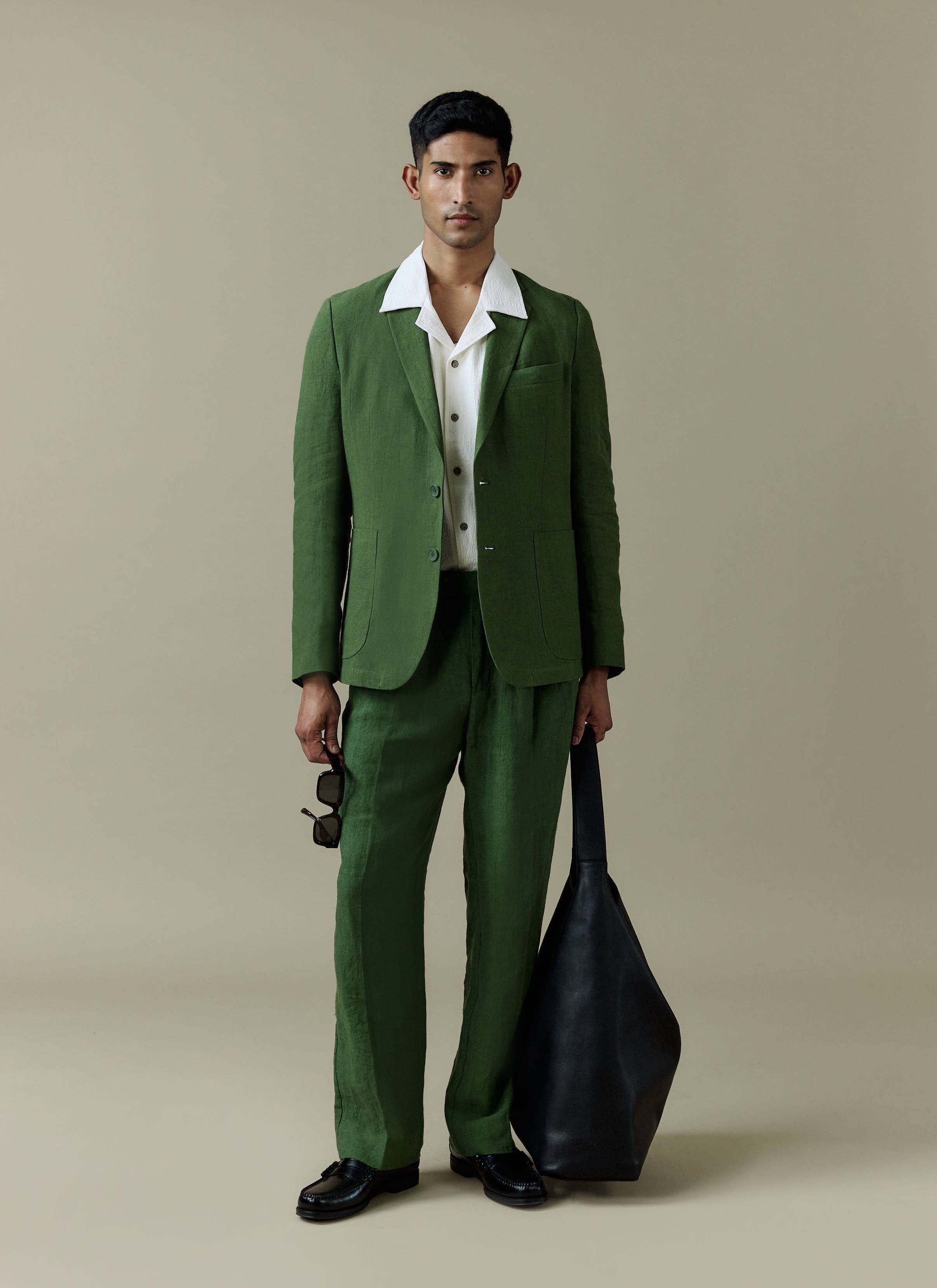 Percival Tailored Linen Blazer and matching trousers in forest green worn by a model with a white textured shirt.