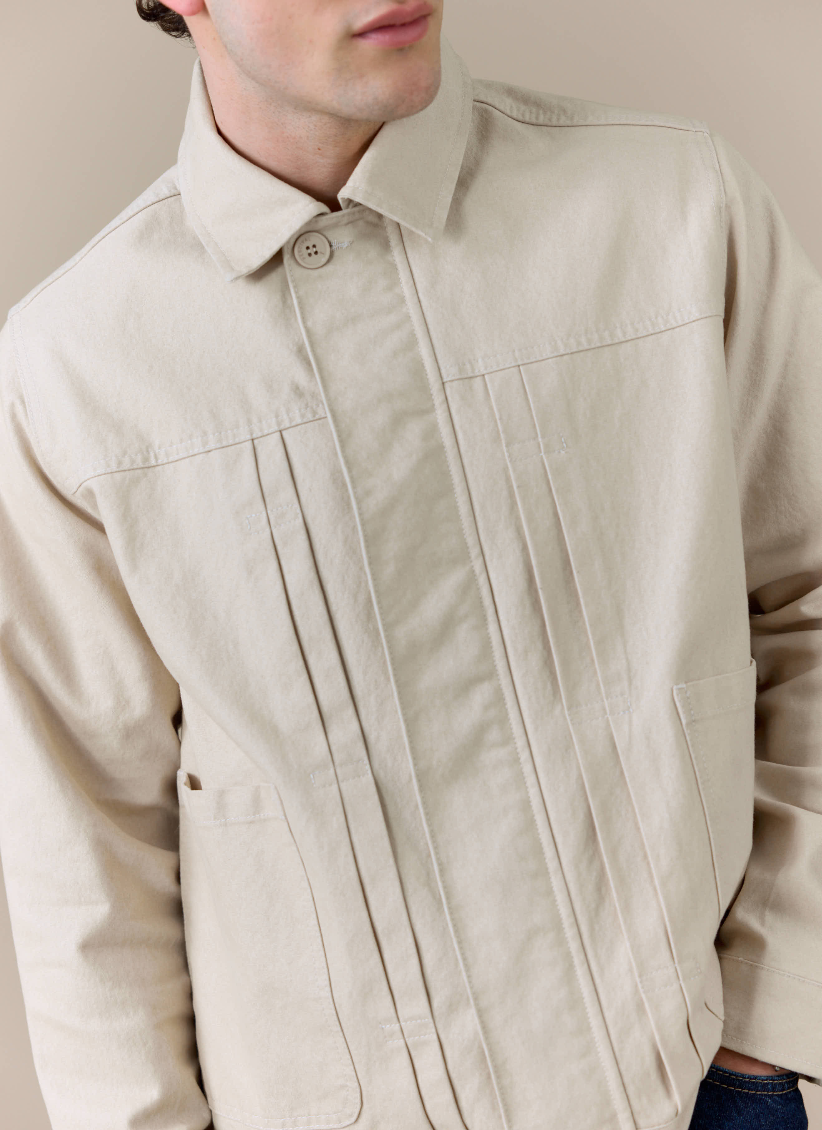 Close-up of the cream Percival Ernst Jacket, showing the structured cotton-blend fabric and double pleated front detail.