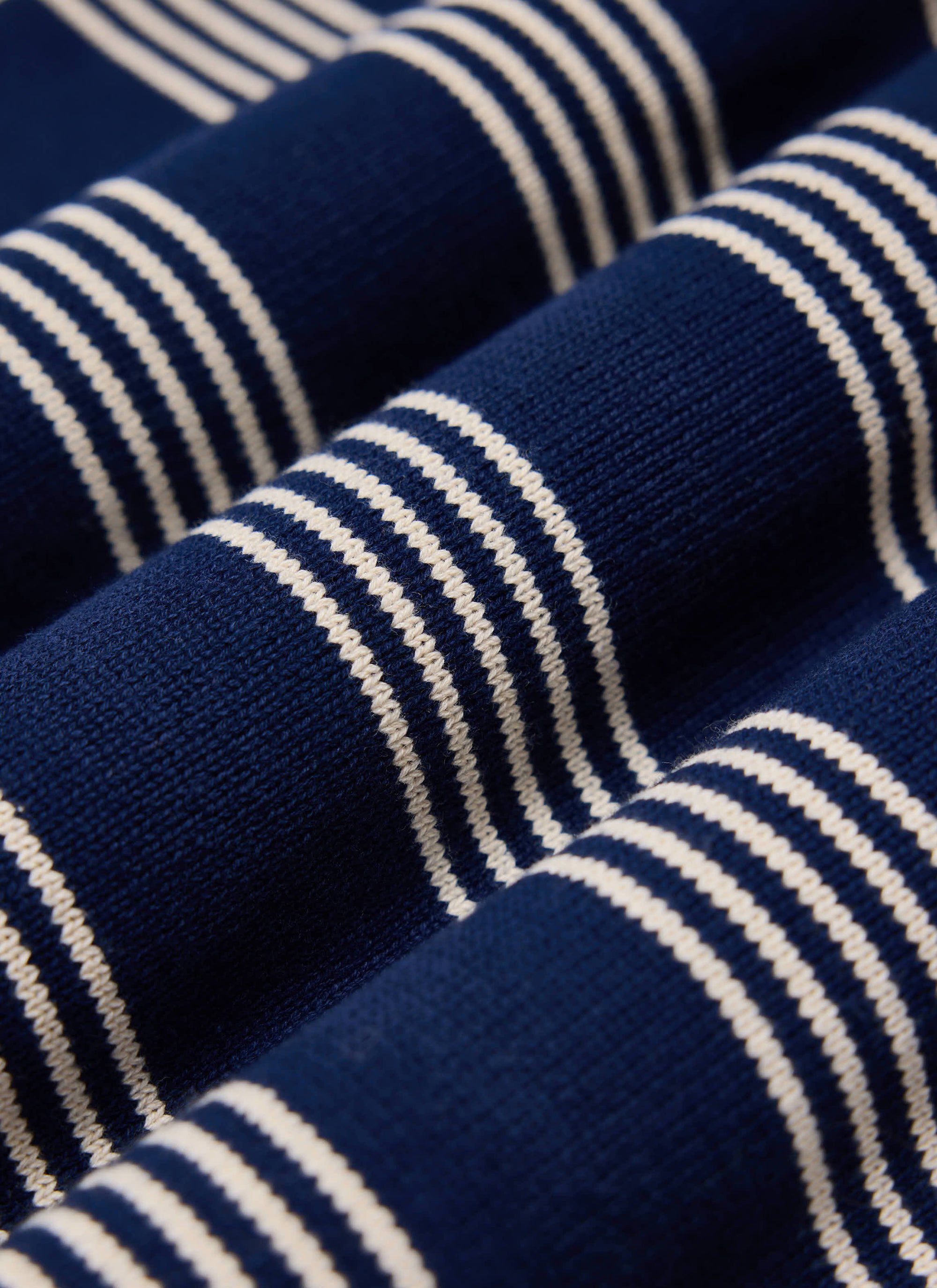 A close-up of the navy and off-white striped cotton knit of the Percival Fiction T-Shirt, showing the texture of the fabric.