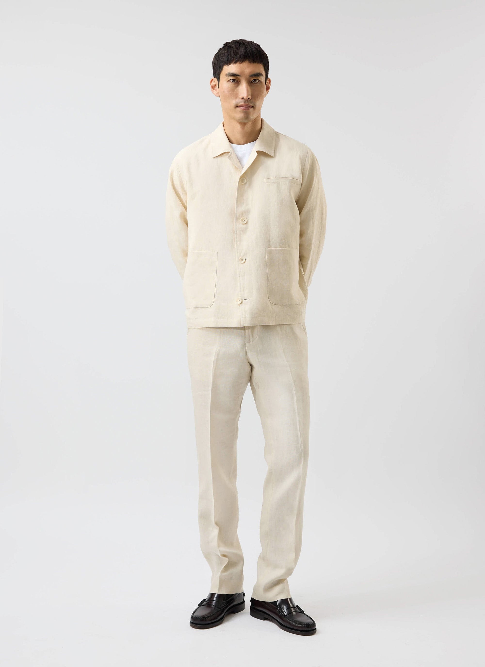 A full-length studio shot of a model wearing the Percival Relaxed Linen Overshirt in stone with matching trousers.