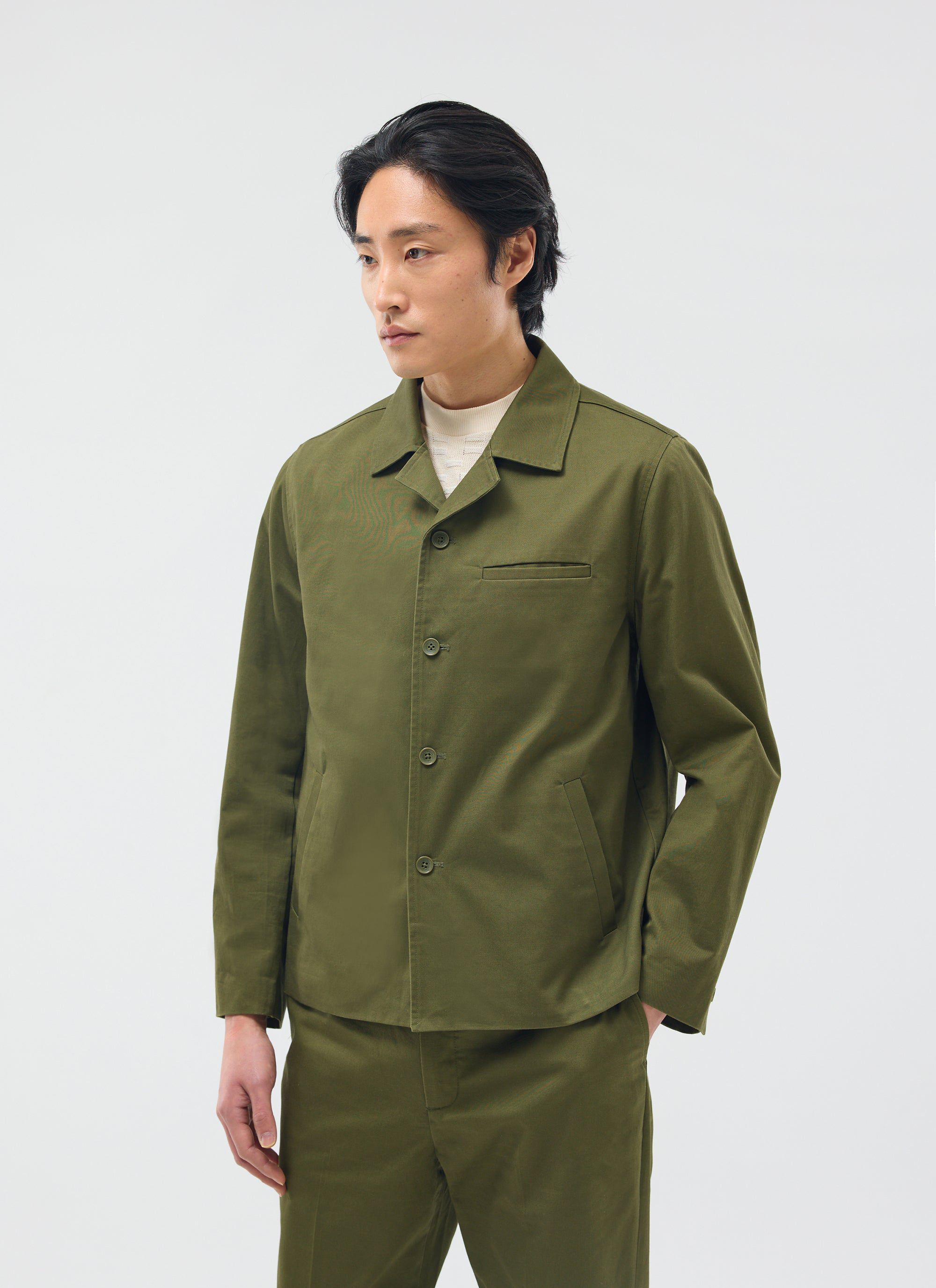 A model wears the Percival Casual Workwear Jacket in khaki cotton, part of a matching set, in a studio.