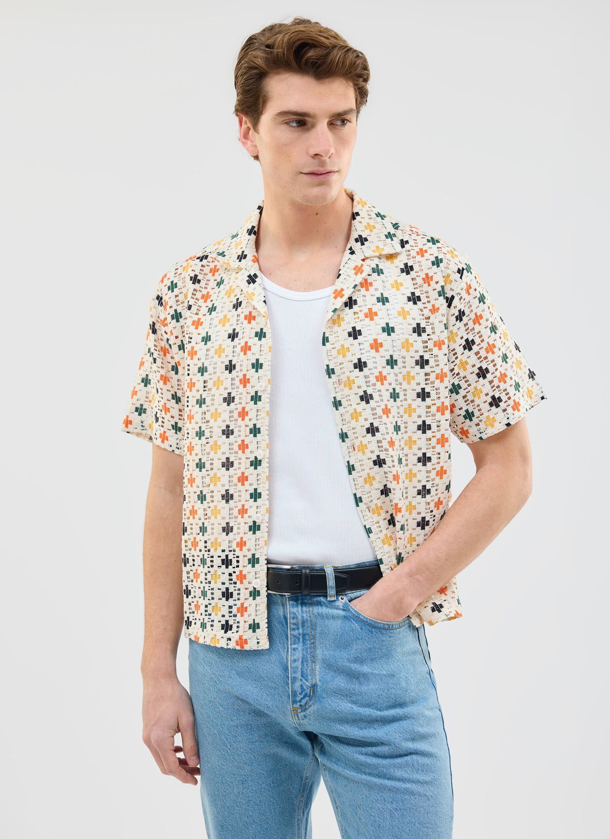 A model wears the Percival Bailing Crochet Cuban Shirt in multi, styled open over a white vest and blue jeans.